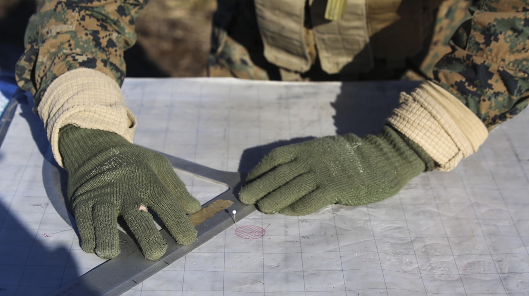 Marines with 1st Battalion, 10th Marine Regiment, 2nd Marine Division, plot out their firing scheme during a live-fire training exercise aboard Landing Zone Dodo, Camp Lejeune, North Carolina, Feb. 19, 2015. The Marines graphed the approximate location of where the rounds fired out of the M777-A2 Howitzer would land so they could adjust their fire accordingly to be more effective. (U.S. Marine Corps photo by Cpl. Kaitlyn Klein/Released)