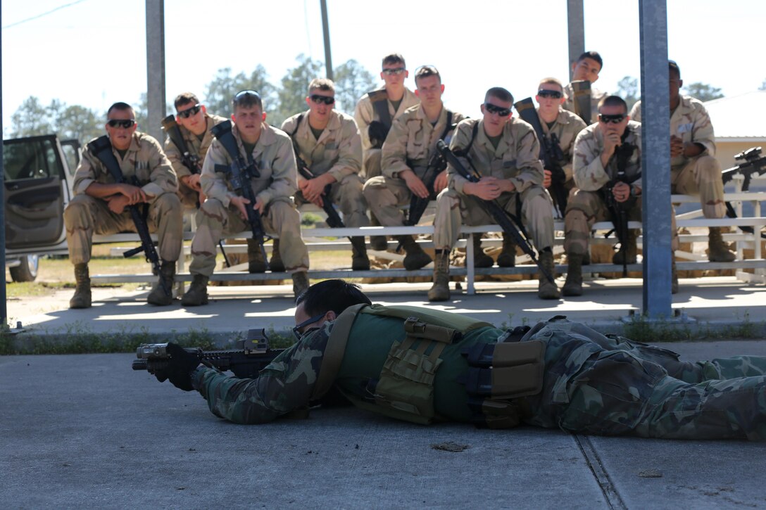 A Critical Skills Operator with 3rd Marine Special Operations Battalion, U.S. Marine Corps Forces Special Operations Command, teaches Marines with 2nd Combat Engineer Battalion, 2nd Marine Division, shooting techniques before firing M4 carbine rifles and M9 service pistols at a range here, Feb. 10, 2015. Marines with 3rd MSOB participated in RAVEN 15-03, a 10-day realistic military training exercise to enhance the battalion’s readiness for worldwide support to global security. Marines with 2nd CEB played the role of a partner nation force during the exercise. (Official U.S. Marine Corps photo by GySgt. Josh Higgins/released)