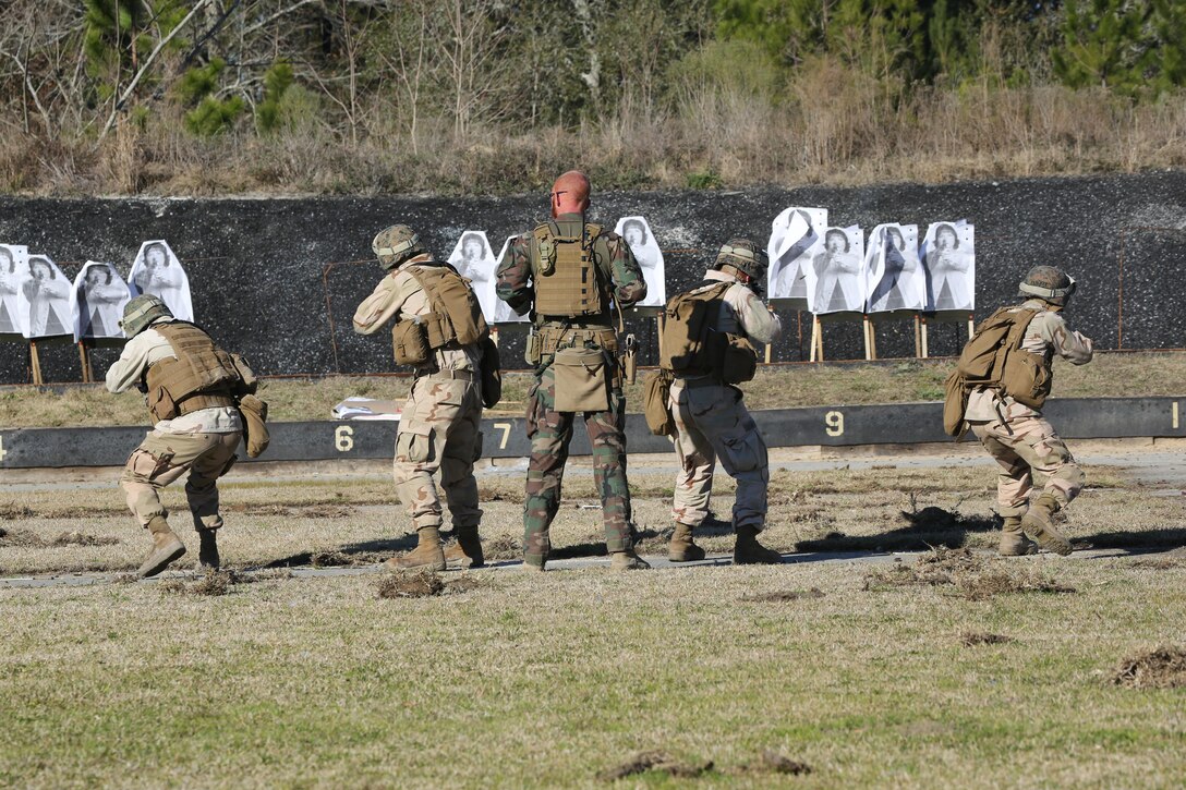 A Critical Skills Operator with 3rd Marine Special Operations Battalion, U.S. Marine Corps Forces Special Operations Command, watches as Marines with 2nd Combat Engineer Battalion, 2nd Marine Division, fire M4 carbine rifles at a range here, Feb. 10, 2015. Marines with 3rd MSOB participated in RAVEN 15-03, a 10-day realistic military training exercise to enhance the battalion’s readiness for worldwide support to global security. Marines with 2nd CEB played the role of a partner nation force during the exercise. (Official U.S. Marine Corps photo by GySgt. Josh Higgins/released)