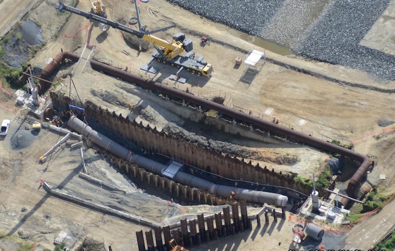 In the photo, the old siphon was demolished and the construction crew is using a crane to install the replacement siphon. Once in place, the crew will weld the new pipe together and cover it up. Once completed, the project will help provide flood risk reduction for years to come.