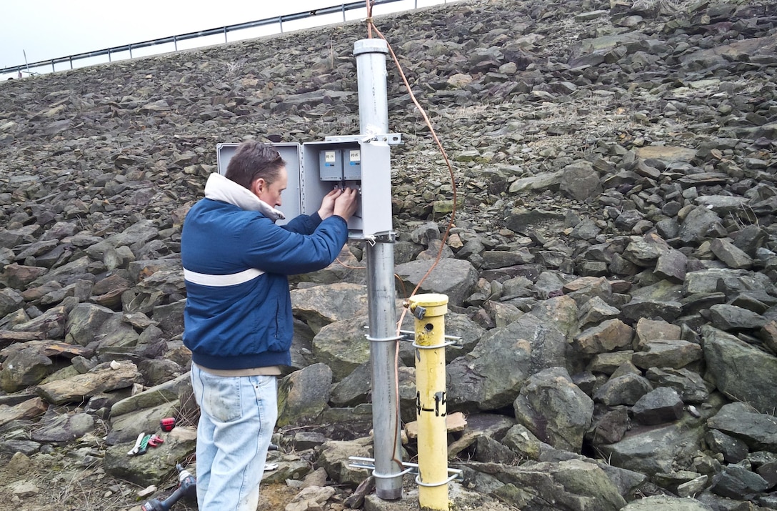 Joe Premozic works to adjust dataloggers in the newly installed permanent enclosure for piezometers at Crooked Creek Dam