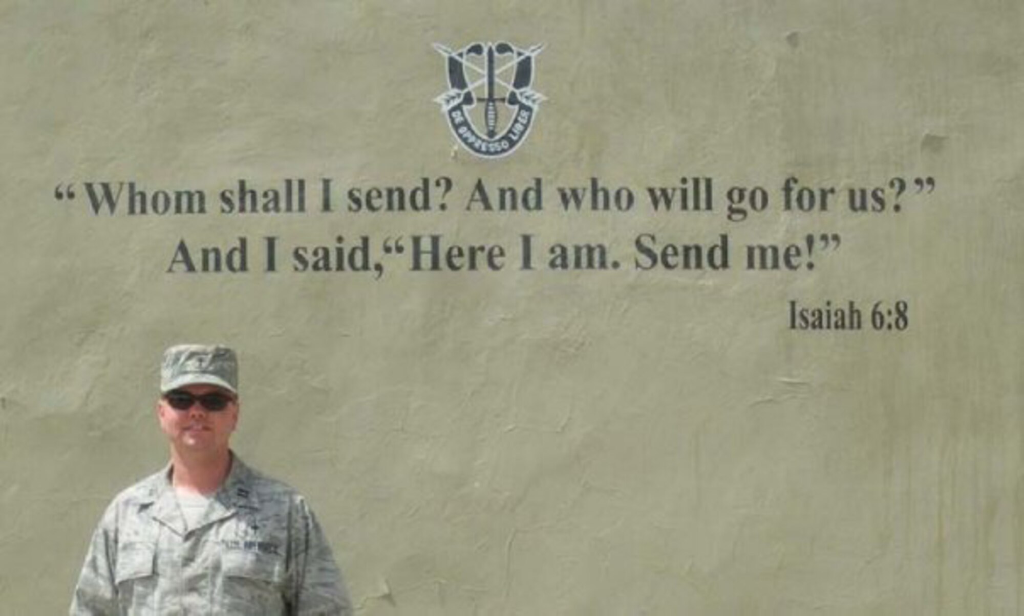 Then Capt. Matthew Boyd stands next to the motto of a special operations unit he deployed with in 2009 as their chaplain in the Middle East. Now a major, Boyd joined the Air Force and pursued his passion in religion after finishing his career as a howitzer cannon crew member for the Army Reserve. (Courtesy photo)