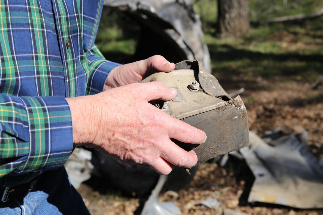 Robert Jones, former Navy pilot with then Attack Squadron (VA) 146, holds a piece of wreckage of his FJ-4B Fury at Rancho Guejito in Escondido, Calif., Feb. 5. Jones ejected from the plane in 1957 and with no knowledge of where it crashed until it was discovered at the ranch.