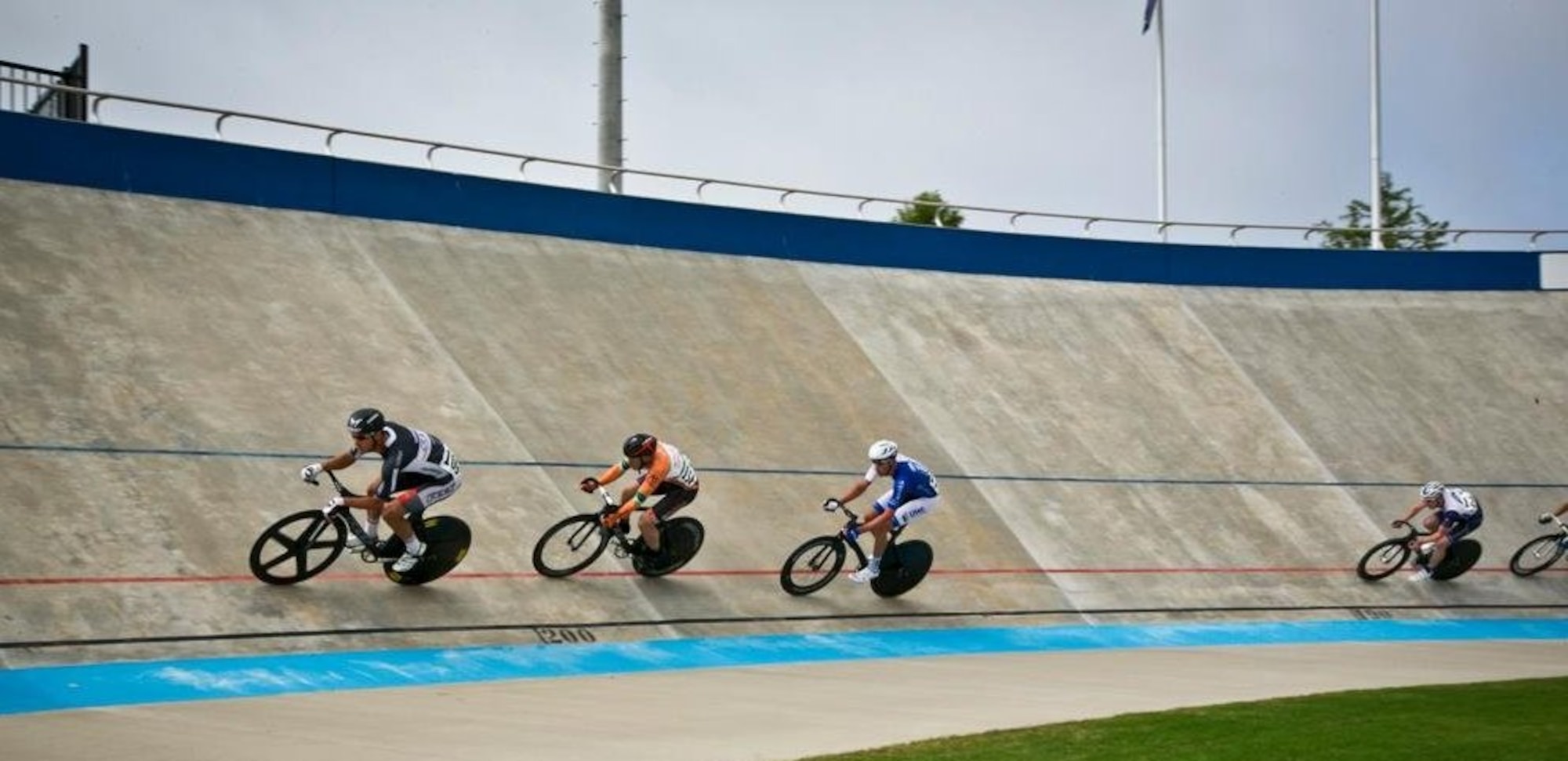 Maj. Ian Holt, orange jersey, fights for position on a velodrome track during the 2014 Elite Nationals in Rock Hill, S.C. Holt is an elite cyclist representing the Air Force and U.S. military in events in America and abroad. Holt is the Headquarters Air Force Space Command vault concepts lead. (Courtesy photo)