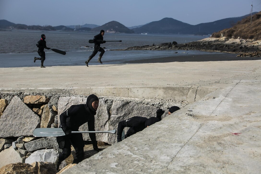 Republic of Korea Marines charge up a beachhead before seeking cover while their counterparts slowly sneak up the shore wall Feb. 5 during Korean Marine Exchange Program 15-3 in Gimpo, Gyeonggi Province, Republic of Korea. The ROK Marines were storming the beach after landing in combat rubber raiding crafts. The training simulated setting up explosive ordinance on an enemy dock or shipyard and leaving without detection. The ROK Marines trained alongside U.S. Marines during KMEP 15-3, enhancing the combat readiness and interoperability of the two forces. The U.S. Marines are reconnaissance men with Alpha Company, 3rd Reconnaissance Battalion, 3rd Marine Division, III Marine Expeditionary Force. The ROK Marines are force reconnaissance men with 2nd Battalion, 2nd Marine Division.