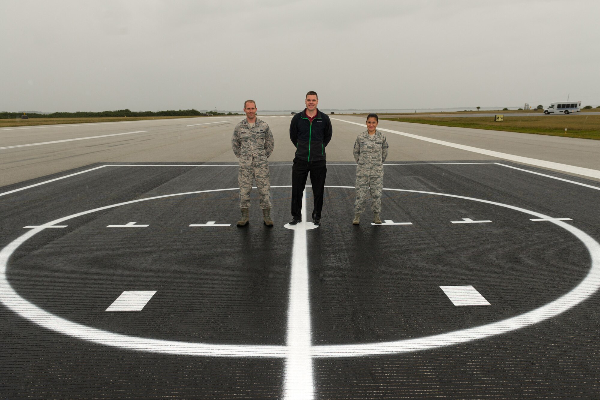 Capt. Gibson Sprott, Michael Coyle, and Master Sgt. Jennifer Shy, of the 45th Operations Support Squadron, stand on one of the two deck landing pads recently installed on Patrick Air Force Base, Florida, Feb. 2, 2015.  These DLPs allow the 920th Rescue Wing, a tenant unit at Patrick AFB, to accomplish annual training at a cost savings to the U.S. Air Force. (U.S. Air Force photo/Cory Long) 