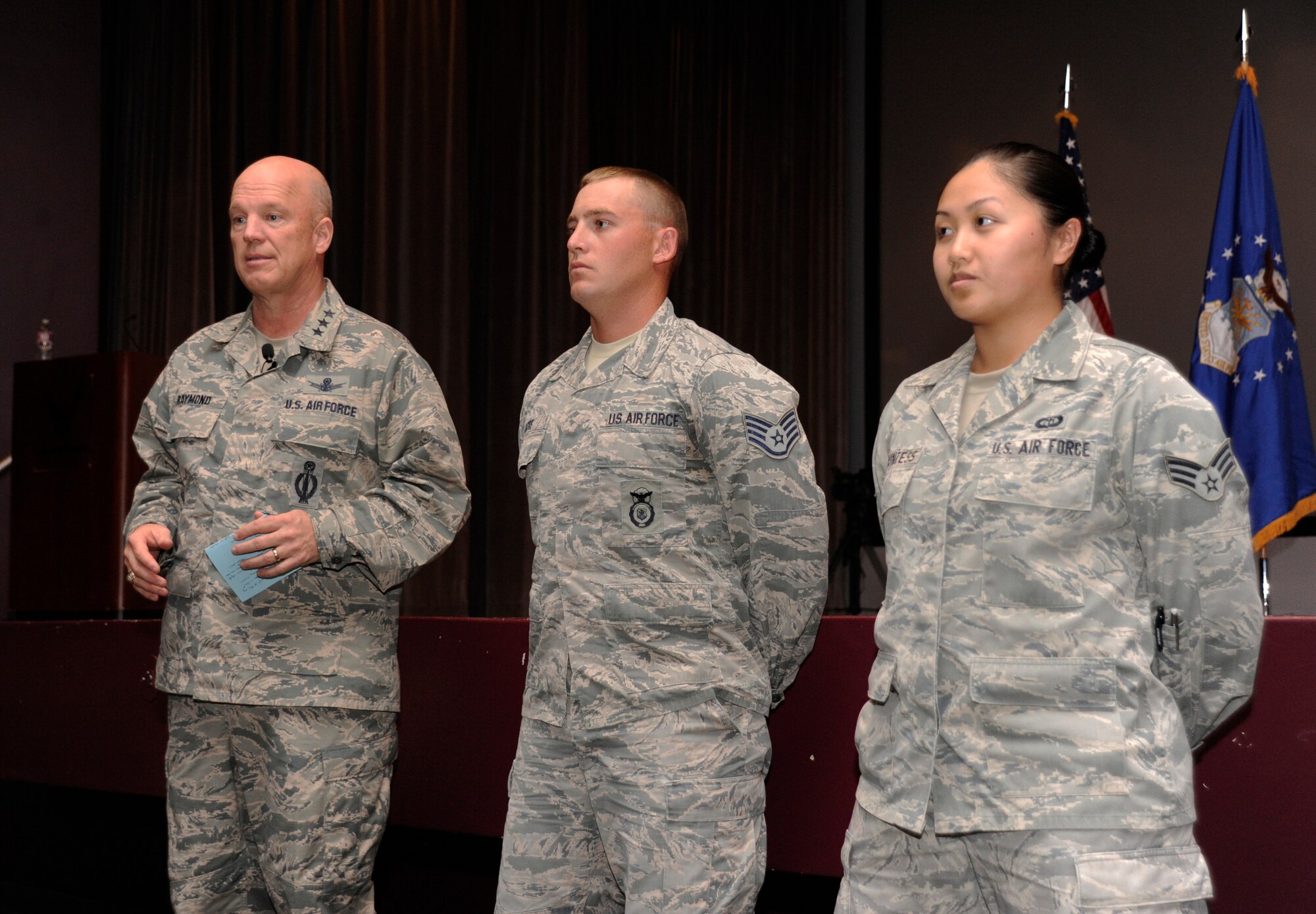 Lt. Gen. John Raymond, Commander, 14th Air Force (Air Forces Strategic) and Joint Functional Component Command for Space, recognizes Staff Sgt. Shawn Acre, 30th Security Forces Squadron patrolman, and Senior Airman Dao Countess, 30th Operations Support Squadron range weather forecaster, during a base all call, Feb. 17, 2015, Vandenberg Air Force Base, Calif. Acre and Countess were recognized amongst their peers for their commitment to Vandenberg’s mission. (U.S. Air Force Photo by Airman Robert J. Volio/Released)