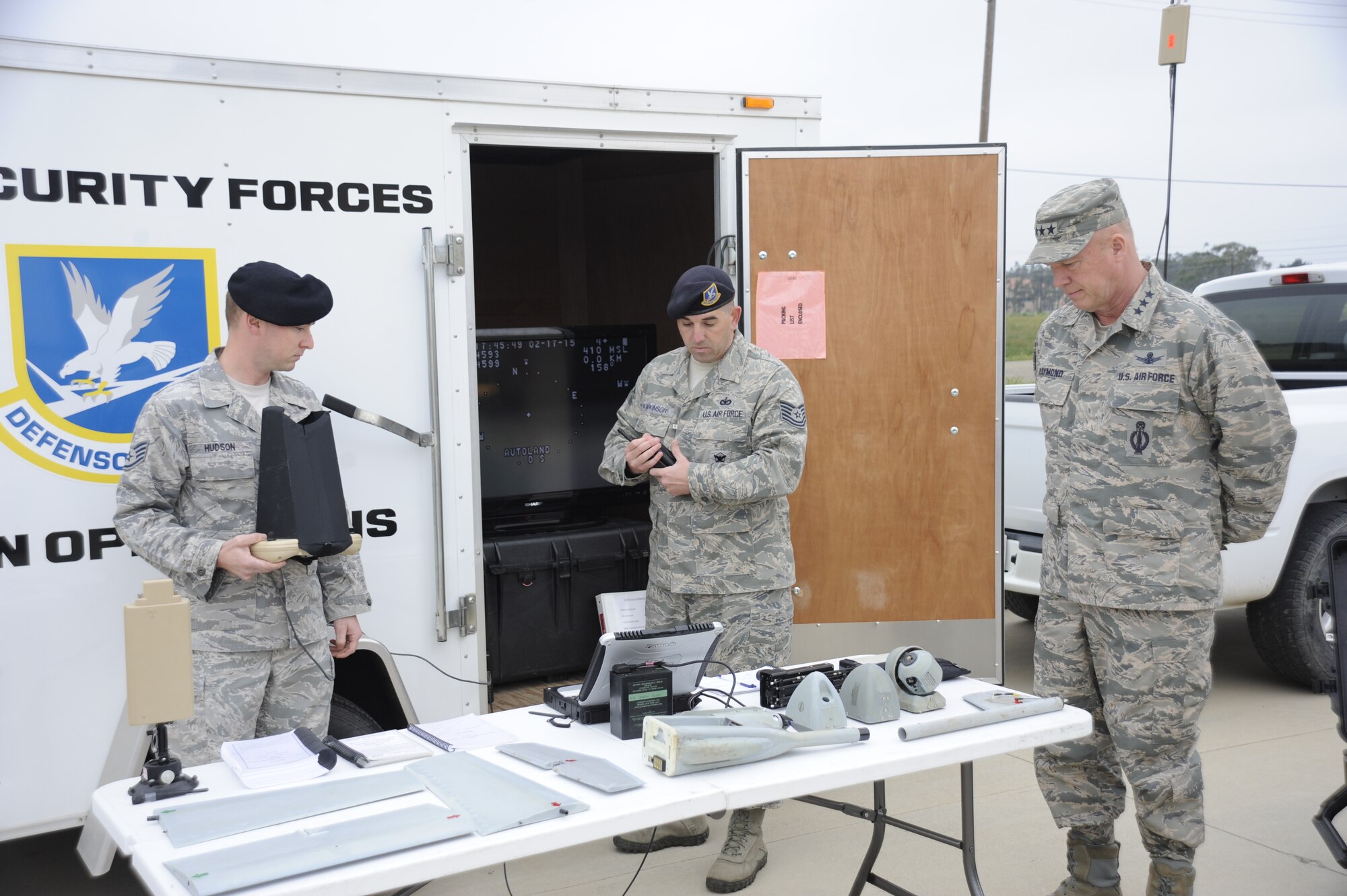 Staff Sgt. Rian Hudson and Tech. Sgt. Benjamin Hawkinson, 30th Security Forces Squadron small unmanned aircraft systems operations, demonstrate unmanned aerial aircraft capabilities to Lt. Gen. John Raymond, Commander, 14th Air Force (Air Forces Strategic) and Joint Functional Component Command for Space, during a base tour, Feb. 17, 2015, Vandenberg Air Force Base, Calif. The model of Unmanned Aerial Vehicle employed at Vandenberg, known as Raven-B/DDL, requires two security forces operators and is utilized for its ample reconnaissance capabilities. (U.S. Air Force Photo by Airman Robert J. Volio/Released)