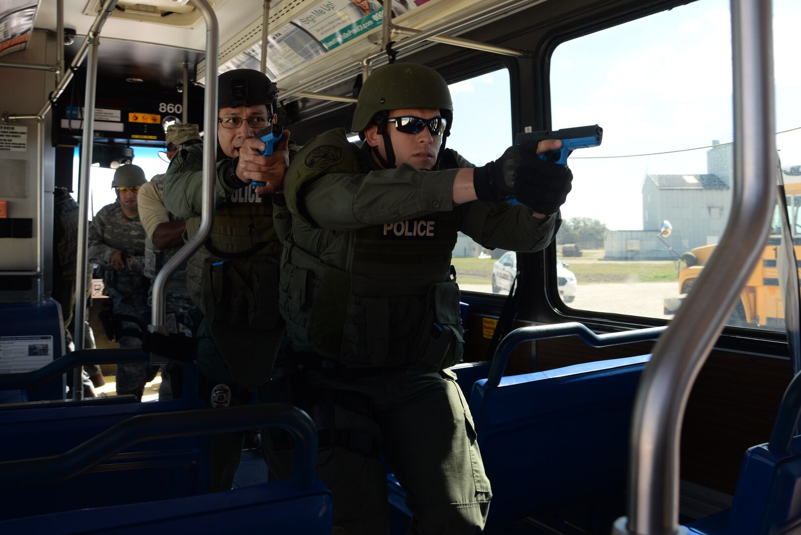 Officer John Salas, Judson Independent School District Police Department patrolman, and Officer Rich Radziski, Converse Police Department patrolman, board a city bus during a hostage rescue exercise Feb. 19, 2015 at Joint Base San Antonio-Randolph Camp Talon Fire Training Ground. The local agencies involved in the exercise were from the cities of Live, Oak Universal City and Converse and the Judson Independent School District Police Departments. Security Forces and local police departments trained together to prepare for emergencies that require both military and civilian response efforts. (U.S. Air Force photo by Airman 1st Class Stormy Archer/Released)
