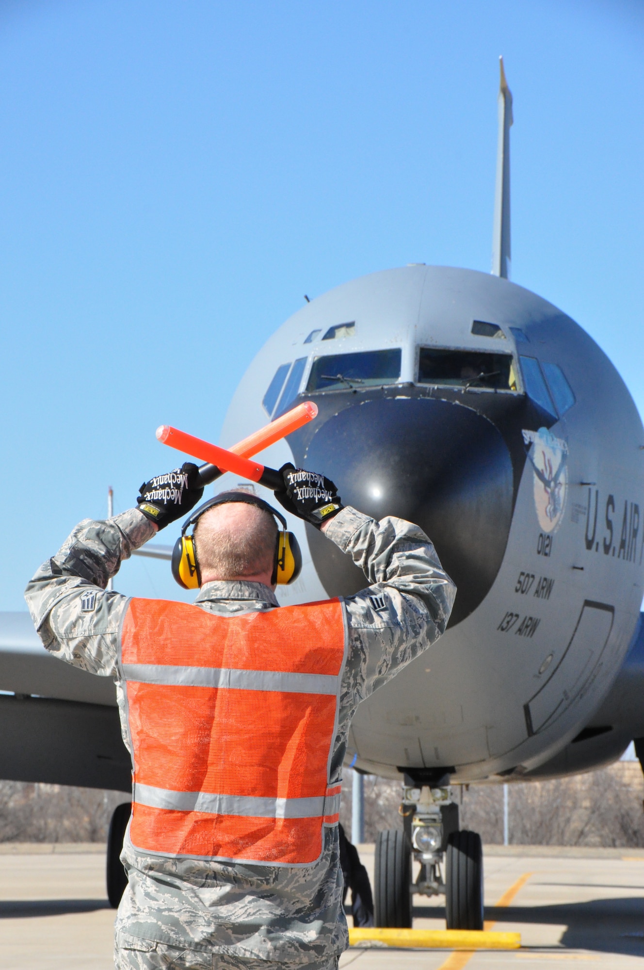 Senior Airman Randy Thompson, 507th Aircraft Maintenance Squadron marshals a KC-135 crew into their parking spot. This flight was one of the first spouse flights the wing hosted in many years.  (U.S. Air Force Photo/Maj. Jon Quinlan)