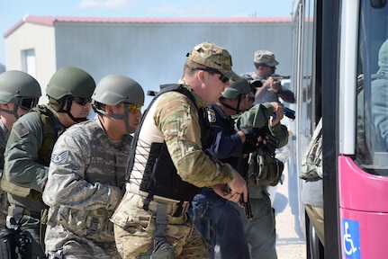 Members from the 902nd and 802nd Security forces Squadrons and police officers from local police departments board a city bus during a hostage rescue exercise Feb. 19, 2015 at Joint Base San Antonio-Randolph Camp Talon. The local agencies involved in the exercise were from the cities of Live, Oak Universal City and Converse and the Judson Independent School District Police Departments. Security Forces and local police departments trained together to prepare for emergencies that require both military and civilian response efforts. (U.S. Air Force photo by Airman 1st Class Stormy Archer/Released)
