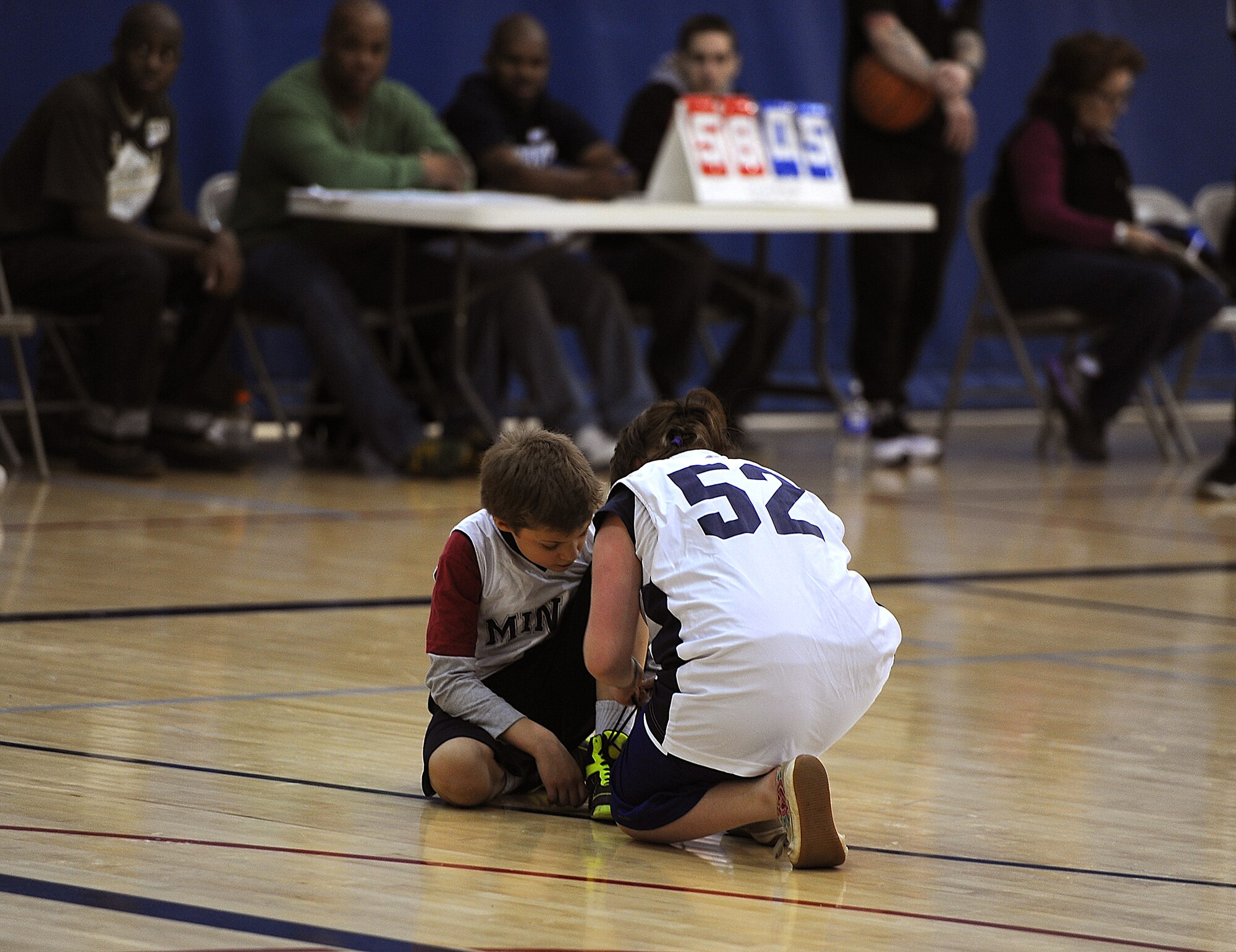 MINOT AIR FORCE BASE, N.D. -- A Special Olympics athlete helps a teammate tie his shoe during the regional basketball tournament at the McAdoo Fitness Center on Minot Air Force Base, N.D., Feb. 21, 2015. The tournament was a stepping stone to the state-level competition, which will be held next month in downtown Minot. (U.S. Air Force photo/Senior Airman Kristoffer Kaubisch)