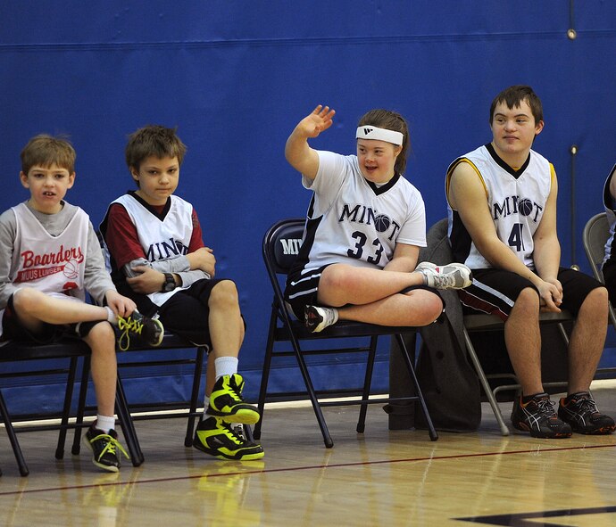 MINOT AIR FORCE BASE, N.D. -- A Special Olympics athlete waves at her family and friends in the stands during the regional basketball tournament at the McAdoo Fitness Center on Minot Air Force Base, N.D., Feb. 21, 2015. The tournament was a stepping stone to the state-level competition, which will be held next month in downtown Minot. (U.S. Air Force photo/Senior Airman Kristoffer Kaubisch)