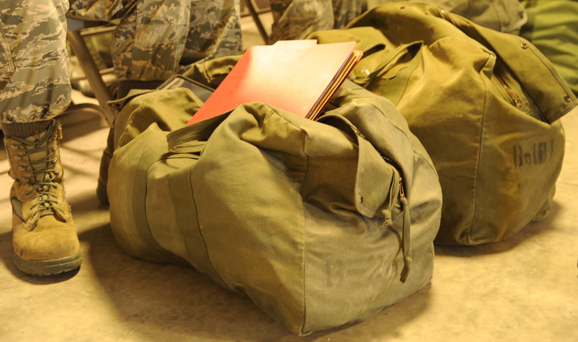 Mobility bags and folders rest at Airmen’s feet during a predeployment exercise Feb. 8, 2015 at MacDill Air Force Base, FL. The bags and folders prepared by 927th mission support personnel, ensure Airmen are prepared to deploy. (U.S. Air Force photo/Senior Airman Xavier Lockley) 