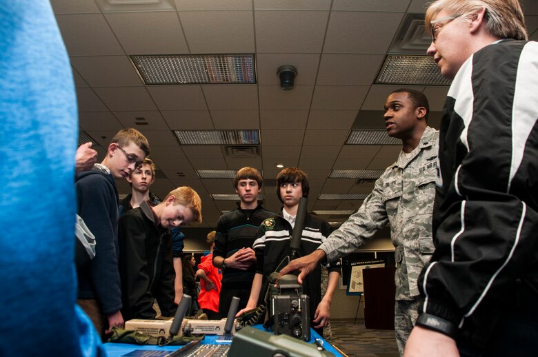 First Lt. Christopher Billups, 2nd Space Operations Squadron, explains the different GPS receivers to Colorado Springs students and teachers as part of GPS Week student outreach Feb. 17, 2015, at Schriever Air Force Base, Colo. The celebration was designed to honor the program’s heritage while interacting directly with the Colorado Springs community. (U.S. Air Force photo/Staff Sgt. Julius Delos Reyes)
