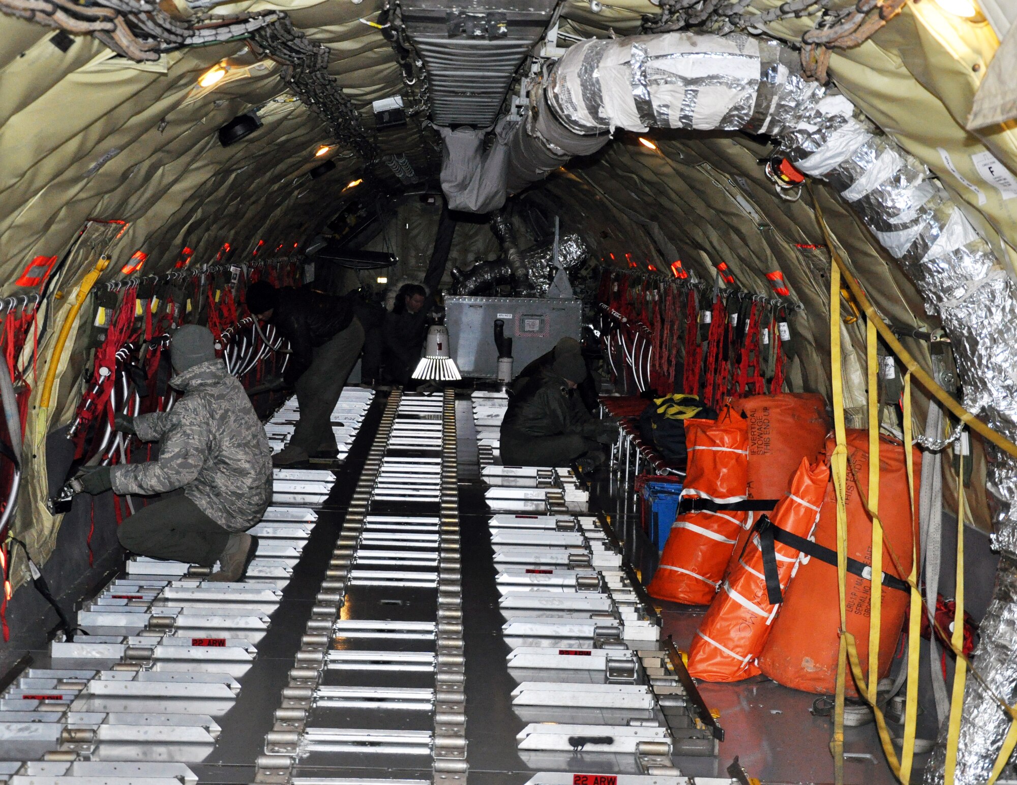 Air refueling boom operators from the active duty 344th Air Refueling Squadron and the Air Force Reserve 18th Air Refueling Squadron work together to prepare a KC-135 Stratotanker for a cargo load at McConnell Air Force Base, Kan., Feb. 23, 2015.  A total force team of logistics personnel and air refueling boom operators from the active duty 22nd Air Refueling Wing and Air Force Reserve 931st Air Refueling Group braved sub-freezing temperatures to load approximately 18,000 pounds of cargo onto the aircraft in preparation for Red Flag. Red Flag is a large-scale military training exercise conducted at Nellis Air Force Base, Nev. (U.S. Air Force photo by Capt. Zach Anderson) 