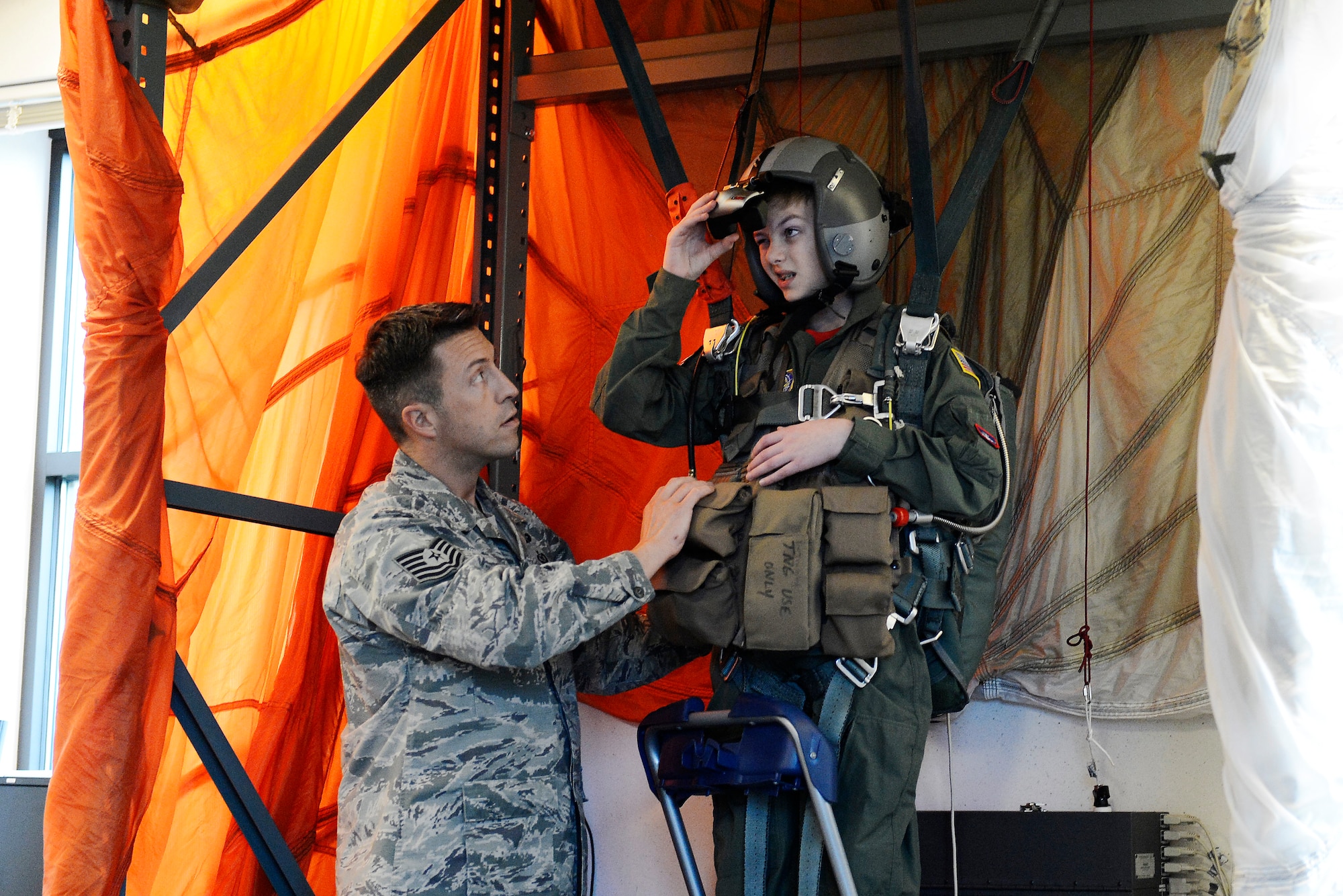 Carver Faull, participant in the Pilot for a Day program, looks into the virtual reality goggles he’ll use to complete his simulated Survival, Evasion, Resistance and Escape parachute training, Feb. 20, 2015, at Joint Base Lewis-McChord, Wash. The goggles simulated falling from 4,000 feet, and Carver’s goal was to navigate the parachute to the sand for a soft landing. (U.S. Air Force photo/Senior Airman Rebecca Blossom)