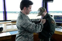 Carver Faull, Team McChord’s Pilot for a Day, receives his Air Traffic Control badge from Capt. Steven Young, 62nd Operations Squadron air field operations flight commander, Feb. 20, 2015, at Joint Base Lewis-McChord, Wash. Carver was recognized as an honorary air traffic controller at McChord Tower and was given his own call sign. (U.S. Air Force photo/Senior Airman Rebecca Blossom)