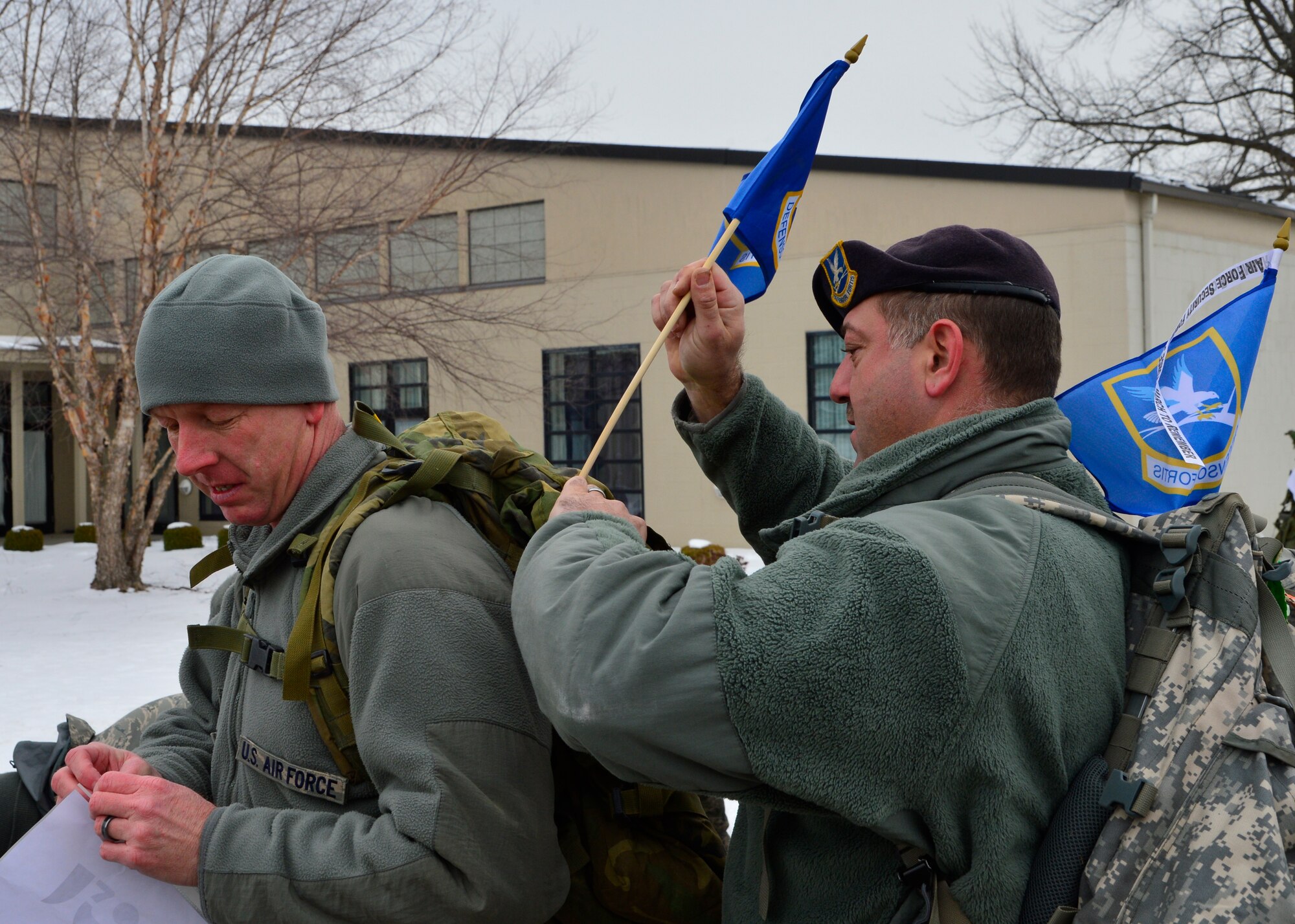 Tech. Sgt. Kenneth Bancroft, right, 436th Security Force Squadron flight chief, attaches a flag to Chief Master Sgt. Christopher Pollock’s, left, 436th Mission Support Group superintendent, ruck sack prior to the beginning of the 16th Annual Security Forces Ruck March Feb. 21, 2015, at Dover Air Force Base, Del. The racers were outfitted with a 30-pound ruck sack and ran on a 6.2 mile course around the perimeter of Dover AFB. (U.S. Air Force photo/Airman 1st Class William Johnson)