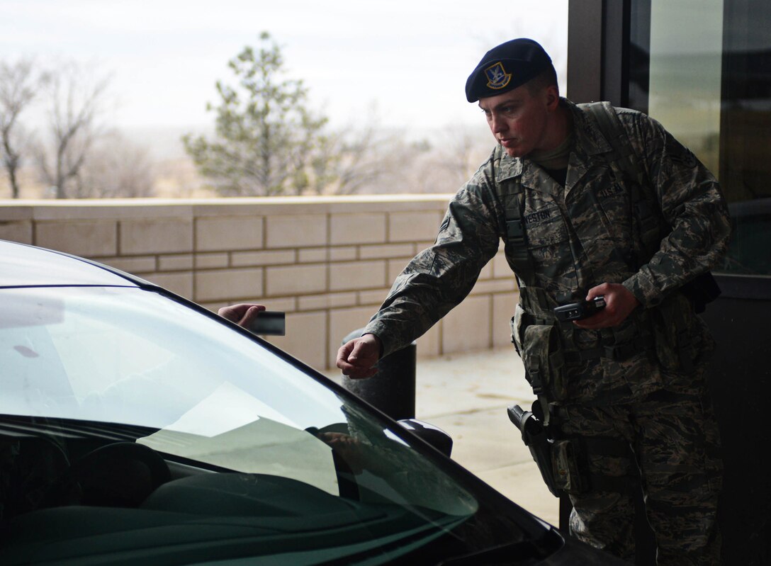 Airman 1st Class Hunter Harveston, 28th Security Forces Squadron response force member, checks an ID card at the Liberty Gate at Ellsworth Air Force Base, S.D., Feb. 12, 2015. 28th SFS defenders use the Defense Biometric Identification System to determine if an individual is authorized entry to the base. (U.S. Air Force photo by Airman 1st Class Zachary Hada/Released)