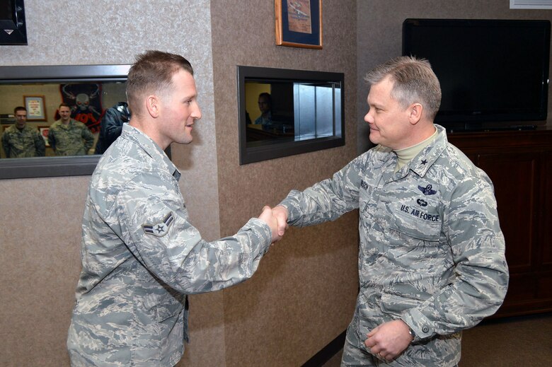 Brig. Gen. Tim Gibson, U.S. Air Force Expeditionary Center vice commander, presents the Expeditionary Center commander’s coin to Airman 1st Class Nels Paskalides, 43rd Logistics Readiness Squadron, recognizing his outstanding duty performance during Gibson’s visit to the 43rd Airlift Group, Pope Army Airfield, N.C. Feb. 19-20. (U.S. Air Force photo/Marvin Krause)