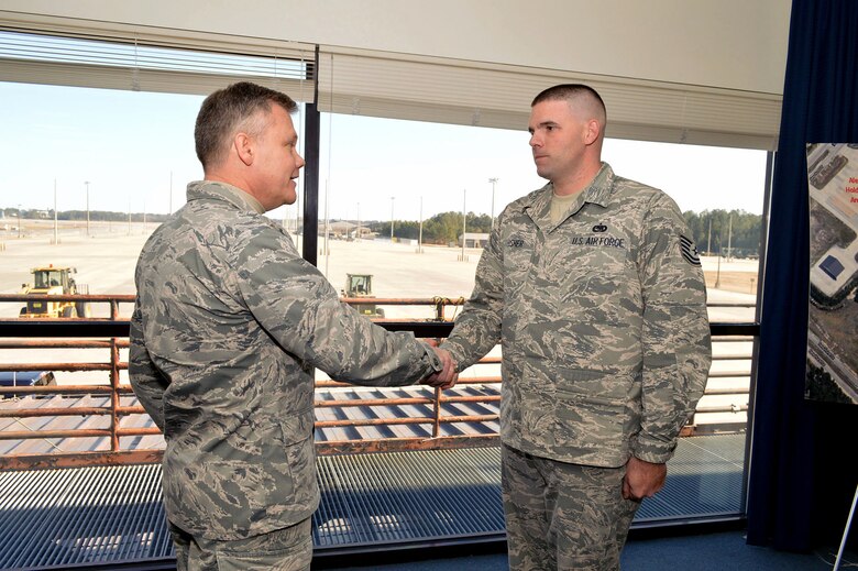 Brig. Gen. Tim Gibson, U.S. Air Force Expeditionary Center vice commander, presents the Expeditionary Center commander’s coin to Tech. Sgt. Brian Fisher, 3rd Aerial Port Squadron, recognizing his outstanding duty performance during Gibson’s visit to the 43rd Airlift Group, Pope Army Airfield, N.C. Feb. 19-20. (U.S. Air Force photo/Marvin Krause)