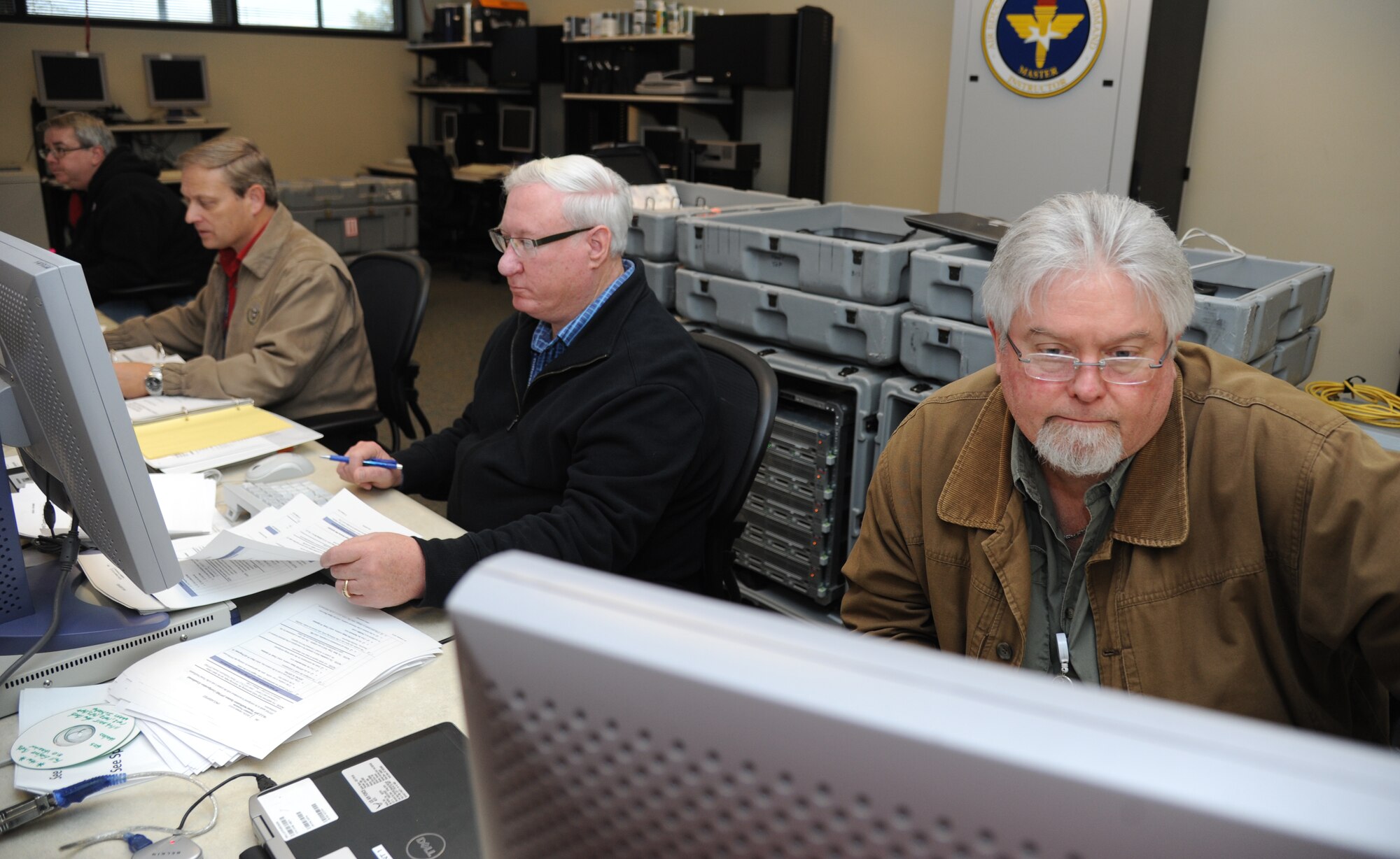 David Bennett, senior instructor, Tim Jung, site lead, Les Powell, system administrator, and James Culpepper, senior instructor for the 336th Training Squadron global command and control systems joint course, set up a GCCS-J mobile training lab Feb. 20, 2015, at Thomson Hall, Keesler Air Force Base, Miss. (U.S. Air Force photo by Kemberly Groue)