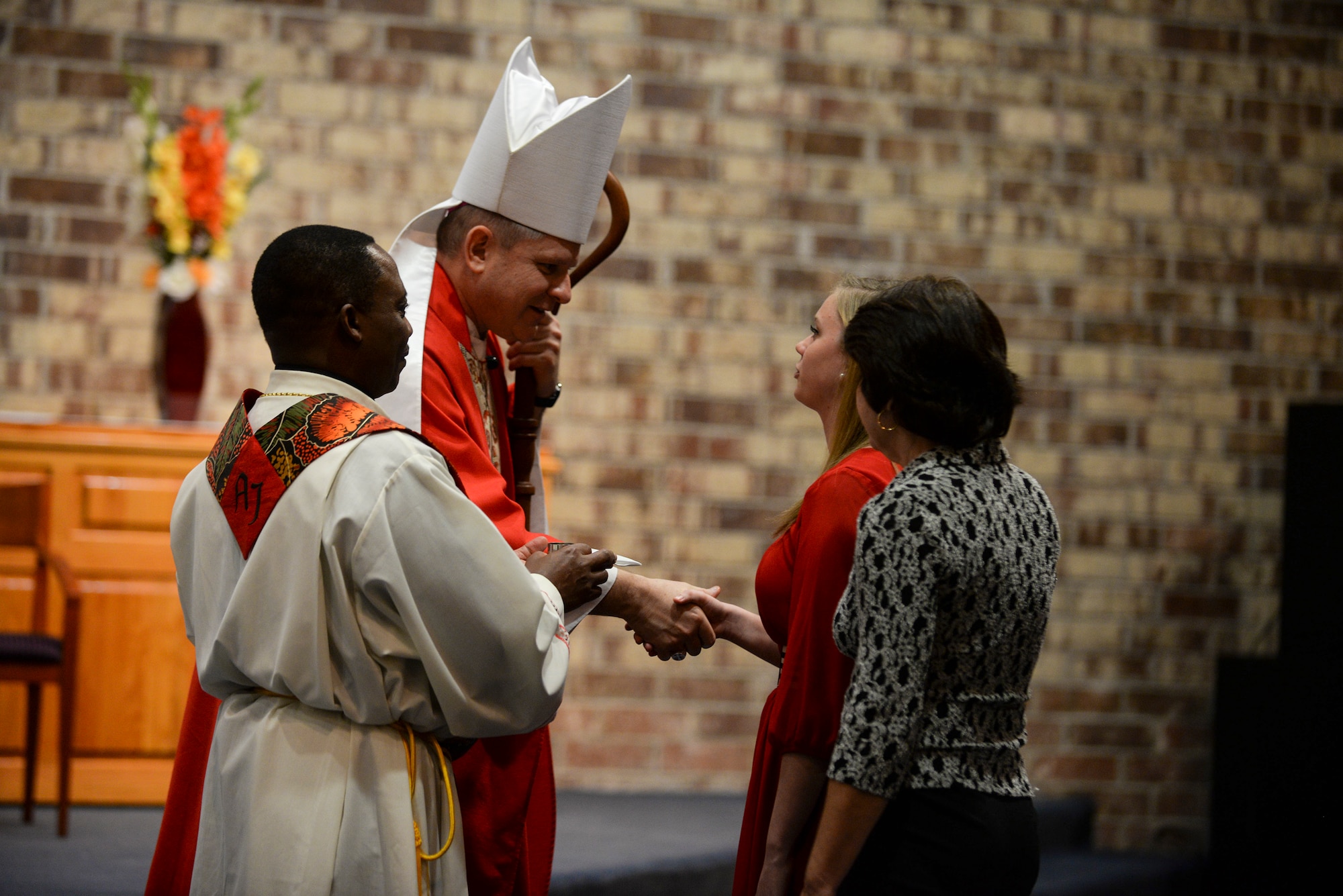 Bishop Robert J. Coyle, auxiliary bishop for the Archdiocese for the Military Services, shakes hands with Kaelyn Estelle, church member, during Confirmation Mass Feb. 17, 2015, at Moody Air Force Base, Ga. Estelle was anointed with chrism oil, a mix of olive oil and balm that was blessed by the bishop. (U.S. Air Force photo by Senior Airman Sandra Marrero/Released)
