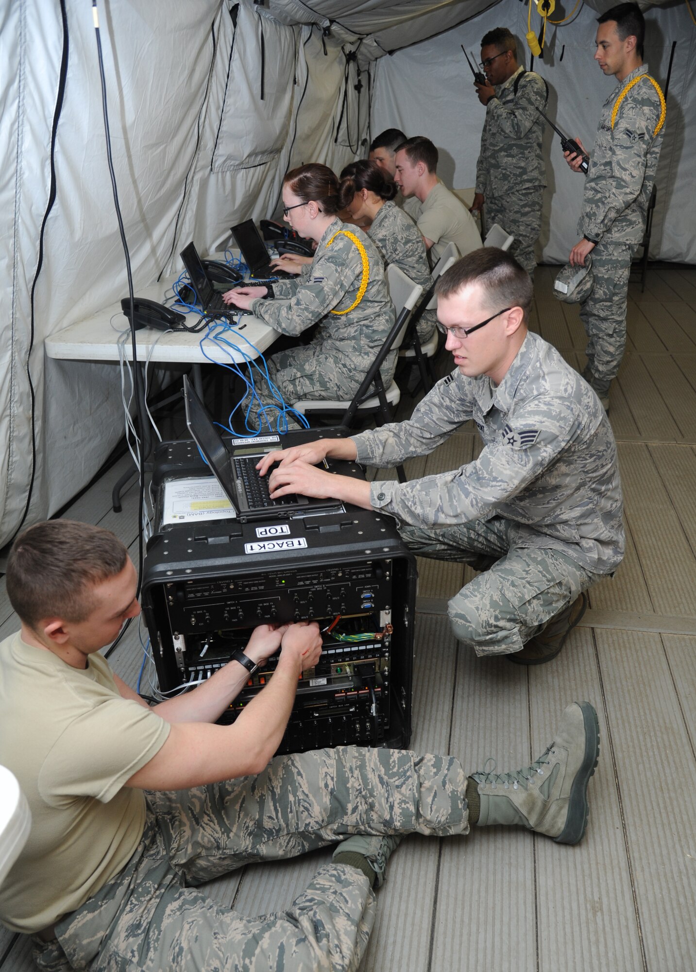 Airman 1st Class Gabriel Plate, 336th Training Squadron student, configures connections for telephones and computer network connections while Senior Airman Jonathan Sargent, 336th TRS student, configures user profiles on the server during the client systems course Feb. 20, 2015, at Keesler Air Force Base, Miss.  (U.S. Air Force photo by Kemberly Groue)