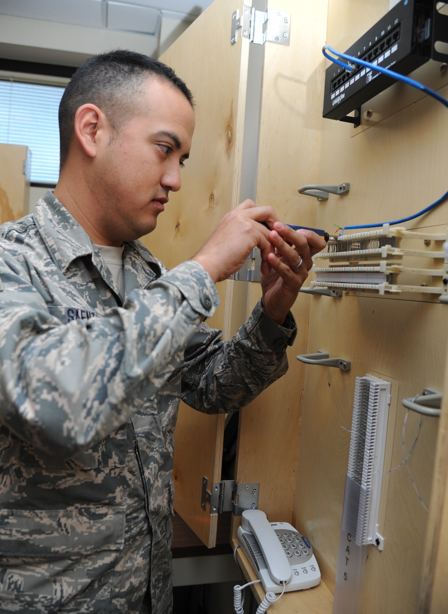 Airman 1st Class Chris Saenz, 336th Training Squadron student, simulates premise wiring for a telephone during the client systems course Feb. 20, 2015, at Thomson Hall, Keesler Air Force Base, Miss.  (U.S. Air Force photo by Kemberly Groue)