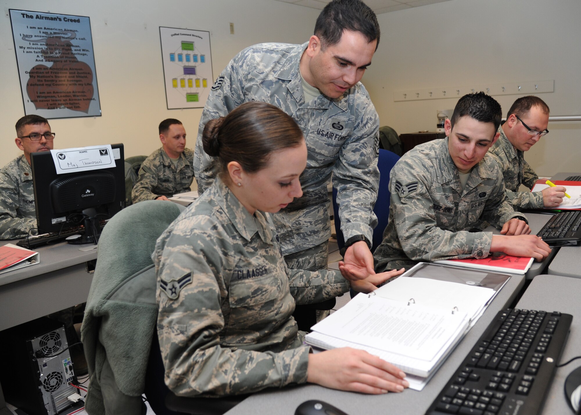 Airman 1st Class Katie Claassen and Senior Airman Tony Vazquez-Denny, 335th Training Squadron students, receive instruction from Staff Sgt. Luis Fernando Sierra, 335th TRS deliberate crisis action planning execution segment instructor, Feb. 19, 2015, at the DCAPES building, Keesler Air Force Base, Miss.  (U.S. Air Force photo by Kemberly Groue)