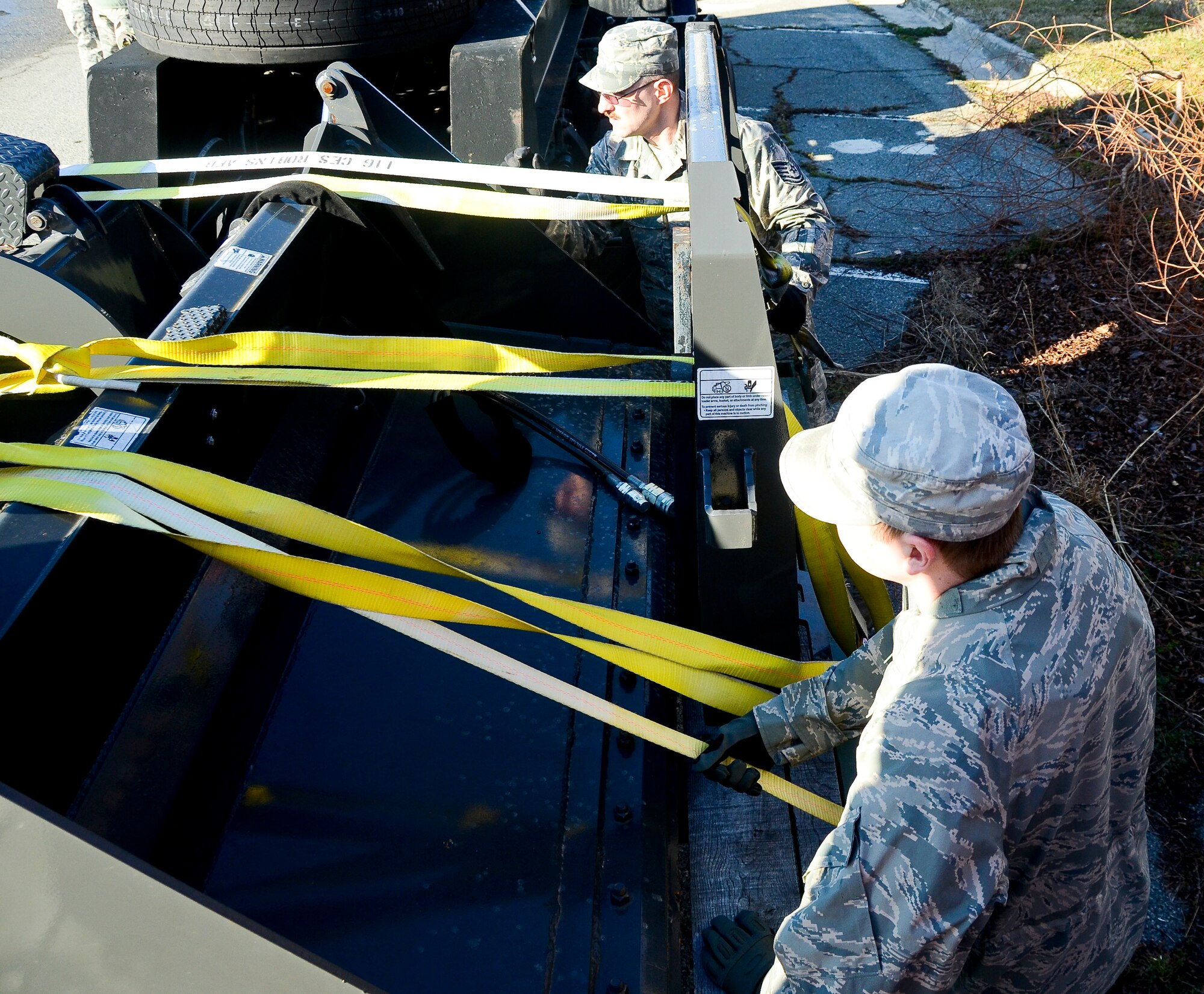 U.S. Air Force Airmen from the 116th Civil Engineering Squadron (CES), Georgia Air National Guard, ensures the straps are tight across snow and debris removal equipment on a flat-bed trailer in preparation for movement to Dobbins Air Reserve Base in response to the Defense Support of Civil Authorities (DSCA) preparation for the potential of inclement weather, Robins Air Force Base, Ga., Feb. 18, 2015. The CES supports the DSCA by utilizing military assets and personnel when authorized by the governor.  The CES provides initial route clearance in response to natural and man-made disasters. (U.S. Air National Guard photo by Tech. Sgt. Regina Young/released) 