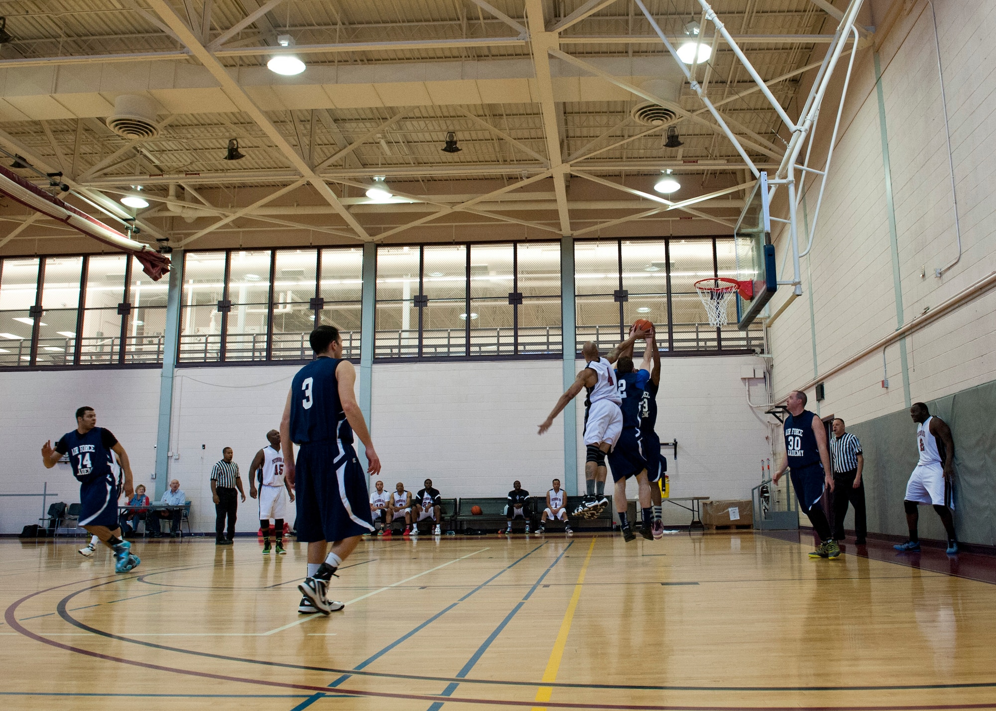 PETERSON AIR FORCE BASE, Colo. – Members of the Peterson AFB and U.S. Air Force Academy basketball teams fight for the ball in a tournament at the Peterson AFB gym, Feb. 14, 2015. Teams from F.E. Warren AFB, Fort Carson and Buckley AFB also participated in the tournament. Peterson AFB won against F.E. Warren 81-67 in the championship game Feb. 15, 2015. (U.S. Air Force photo by Senior Airman Tiffany DeNault)