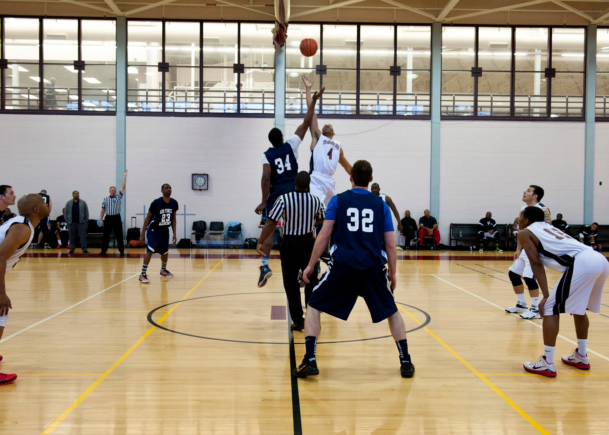 PETERSON AIR FORCE BASE, Colo. – Members of Peterson AFB and U.S. Air Force Academy basketball teams participate in the opening tip-off in a tournament at the Peterson AFB fitness center, Feb. 14, 2015. Teams from F.E. Warren AFB, Fort Carson and Buckley AFB also participated in the tournament. Peterson AFB beat F.E. Warren 81-67 in the championship game Feb. 15, 2015. (U.S. Air Force photo by Senior Airman Tiffany DeNault)