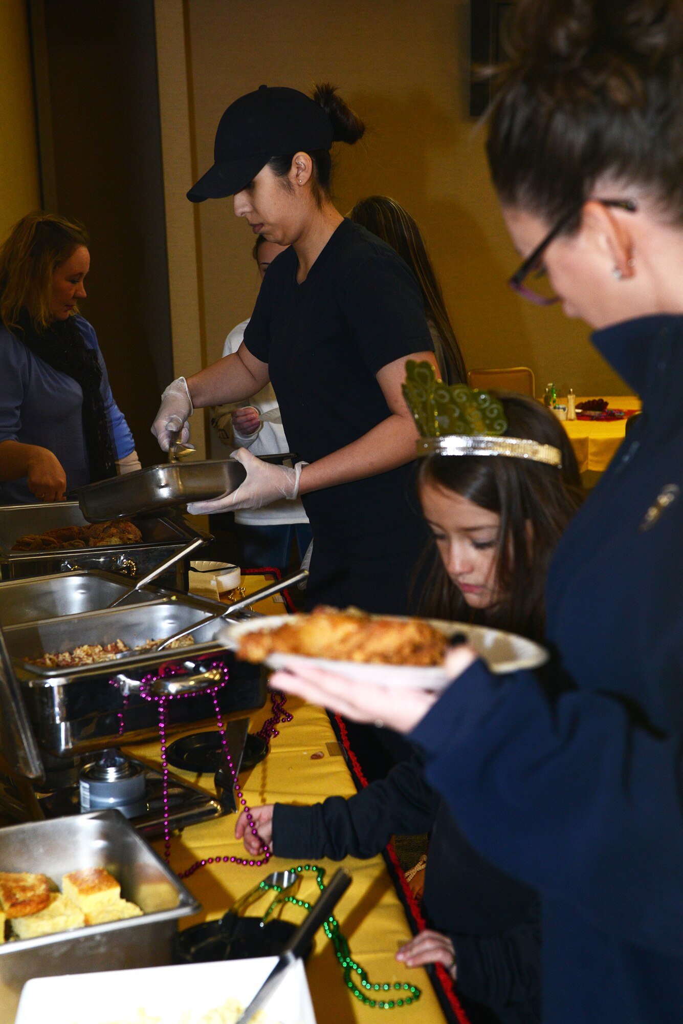 Jessica Perez, 23d Force Support Squadron food service worker, refills the buffet line for the Mardis Gras family dinner Feb. 19, 2015, at Moody Air Force Base, Ga. The food served was Mardi Gras themed red beans and rice, fried chicken, corn, salad, macaroni salad, king cake and ice cream. (U.S. Air Force photo by Airman 1st Class Kathleen D. Bryant/Released)