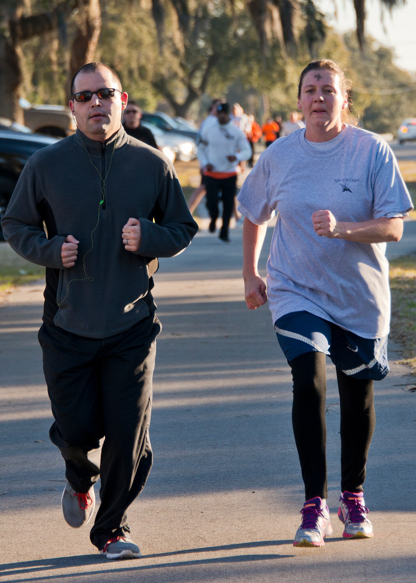 Runners approach the finish line of the Ashes to Dust 5K run Feb. 18 near the Civil Engineering Pavilion on Eglin Air Force Base, Fla. Approximately 225 people attended the event on Ash Wednesday, a day that marks the beginning of the Lent season for Christians.  Eglin’s Chapel held the event to start the season with spiritual and physical inspiration and also the option to receive a cross of ashes for those who wanted to demonstrate their faith. (U.S. Air Force photo/Ilka Cole) 