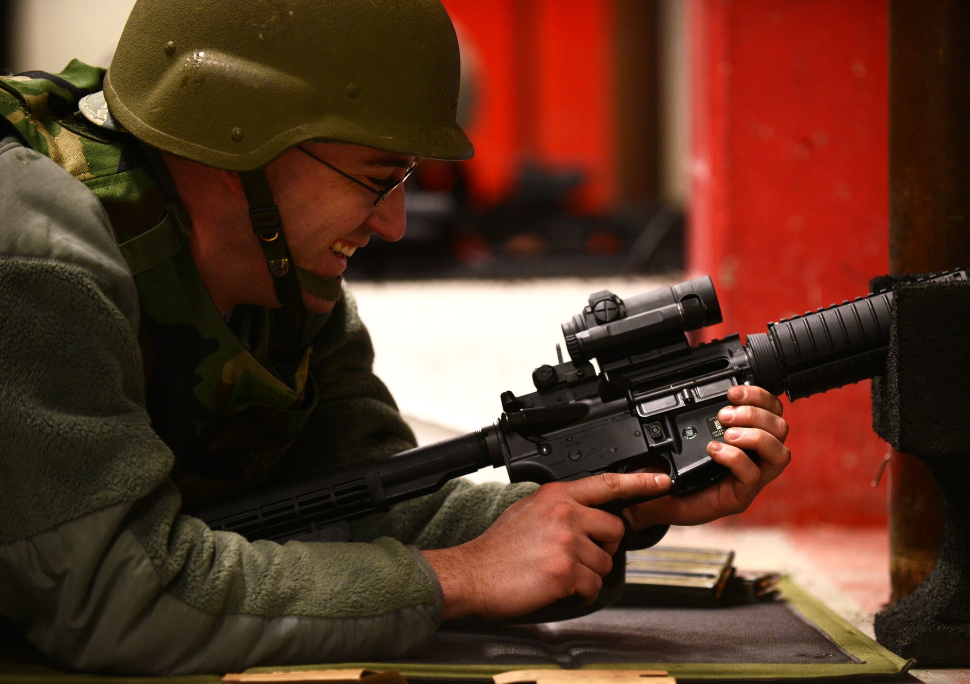 Staff Sgt. Jason Stephan, 1st Combat Communications Squadron radio frequency transmission systems technician, smiles while an instructor from the 569th Combat Arms Training and Maintenance Squadron cracks a joke over the intercom system at the Kaiserslautern Military Community Combat Arms Training and Maintenance Squadron, Vogelweh Military Complex, Germany, Feb. 23, 2015. The KMC CATM has the highest tempo for weapons qualifications within U.S. Air Forces in Europe. (U.S. Air Force photo/Senior Airman Nicole Sikorski)