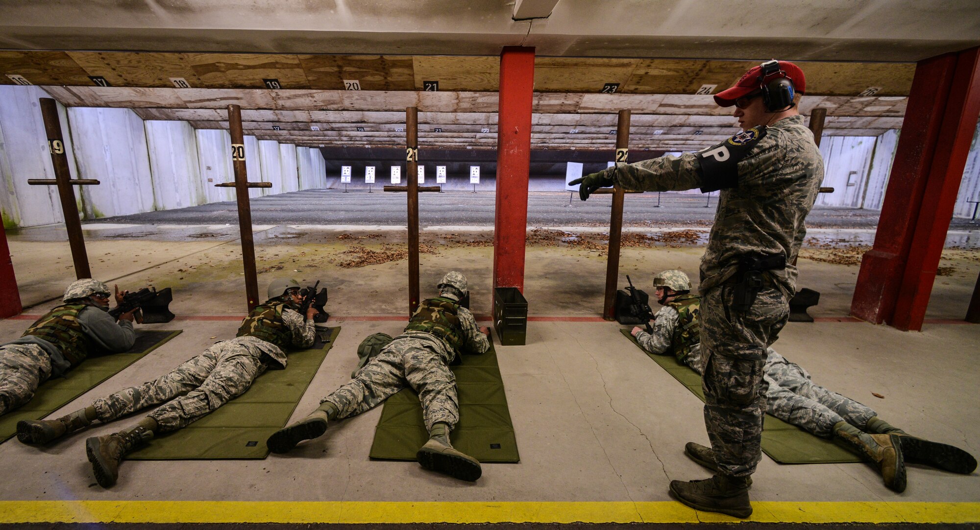Senior Airman Shane Fairchild, 569th Combat Arms Training and Maintenance instructor, observes Airmen during their M-4 carbine qualification test at the Kaiserslautern Military Community Combat Arms Training and Maintenance Squadron, Vogelweh Military Complex, Germany, Feb. 23, 2015. CATM is responsible for all firing qualifications in the KMC area and eight geographical separated units. (U.S. Air Force photo/Senior Airman Nicole Sikorski)