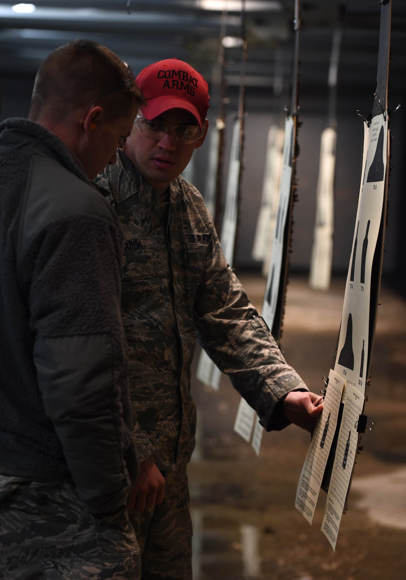 Staff Sgt. Jared Kendrick, 11th Security Forces Squadron Base Defense Operation Center operator, and Staff Sgt. Juan Garcia, Combat Arms instructor, discuss the grouping on the target at the firing range on Joint Base Andrews, Md., Feb. 3, 2015. The grouping give insight to technique mistakes; corrections from Garcia can improve accuracy. (U.S. Air Force photo/Airman 1st Class Philip Bryant)