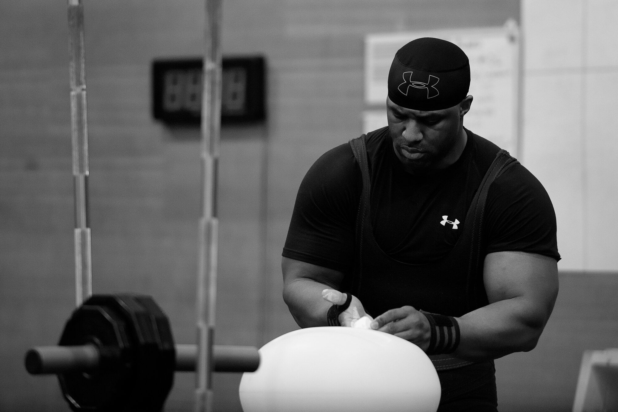 U.S. Navy Petty Officer 1st Class Jonathan Terrell Groves, event competitor, prepares to perform a squat in the 2015 Yokota Powerlifting Invitational held in the Samurai Fitness Center at Yokota Air Base, Japan, Feb. 21, 2015. Groves was one of 20 competitors to test their strength in the invitational. (U.S. Air Force photo by Airman 1st Class Delano Scott/Released)