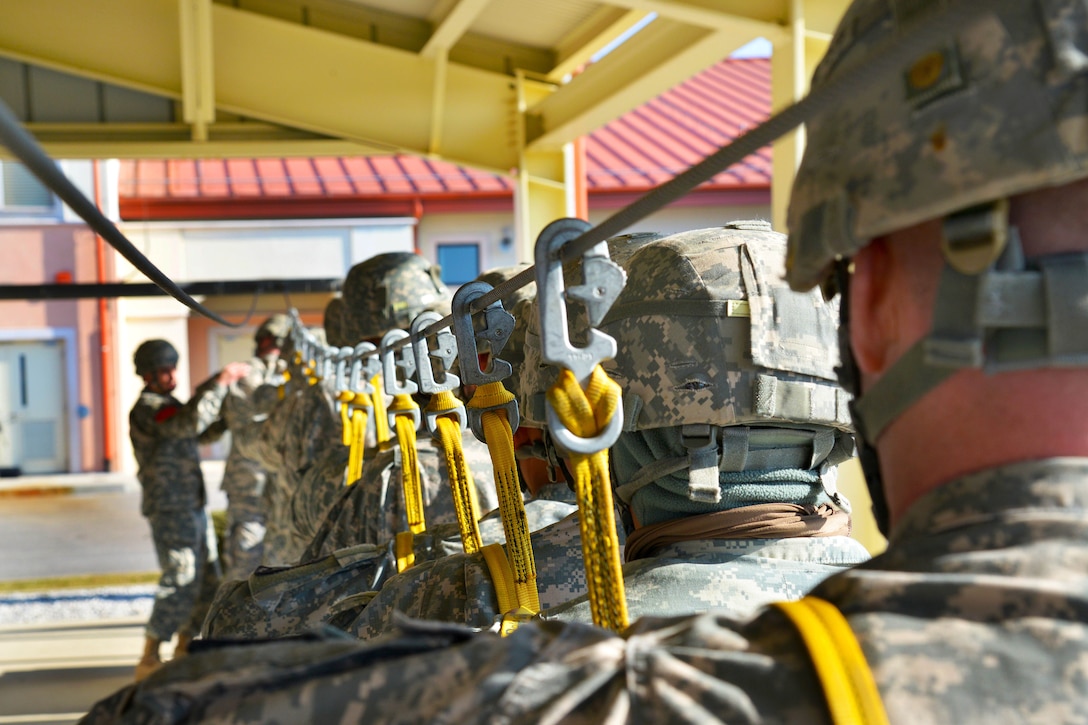 U.S. Army paratroopers pratice hooking up to the static line on Aviano Air Base, Italy, before conducting an airborne operation on Juliet drop zone in Pordenone, Italy, Feb. 19, 2015.