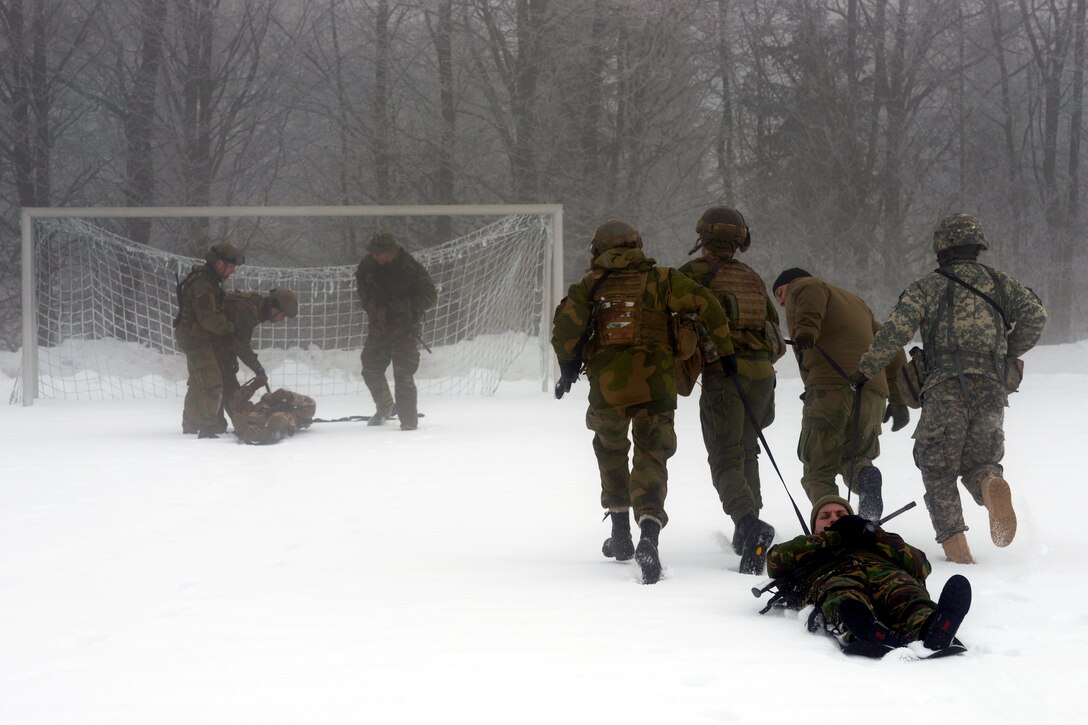 Soldiers drag a simulated casualty on an evacuation stretcher litter during harsh weather conditions during a NATO advanced medical first responder course in Pfullendorf, Germany, Feb. 18, 2015.