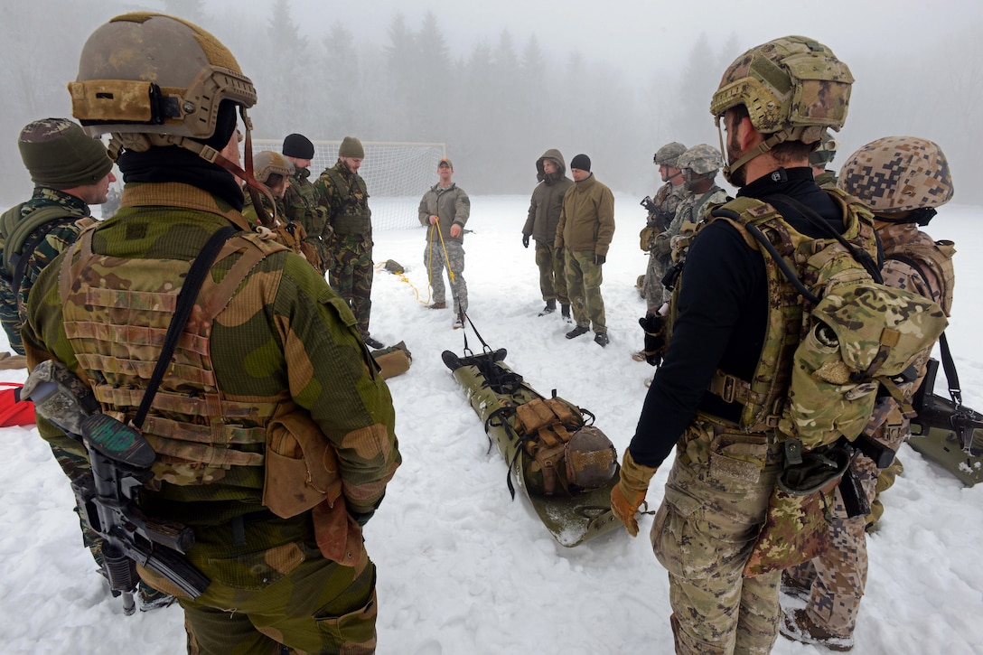 U.S. Army Sgt. Derek D. Niegsch, center, demonstrates how to pull an ...