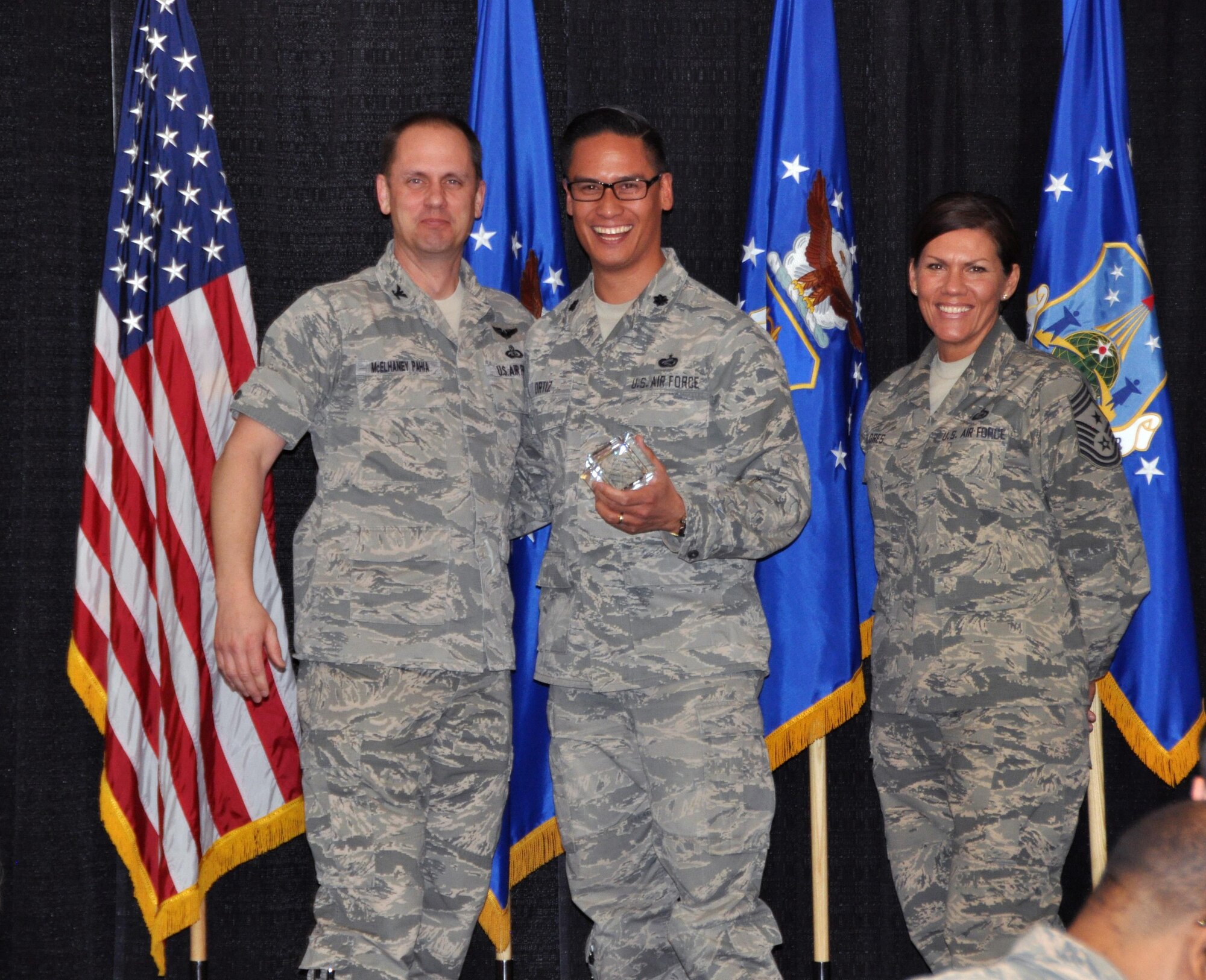 Col. Sean McElhaney Pahia, Air Reserve Personnel Center vice commander, and Chief Master Sgt. Ruthe Flores, ARPC command chief, present the Personnel Field Grade Officer of the Year Air Reserve Component award to Lt. Col. Michael Ortiz. McElhaney Pahia honored ARPC’s 2014 outstanding performers of the year as well as their A1 annual award winners at the Summit Conference and Event Center Feb. 24, 2015, in Denver. (U.S. Air Force photo/Tech. Sgt. Rob Hazelett)