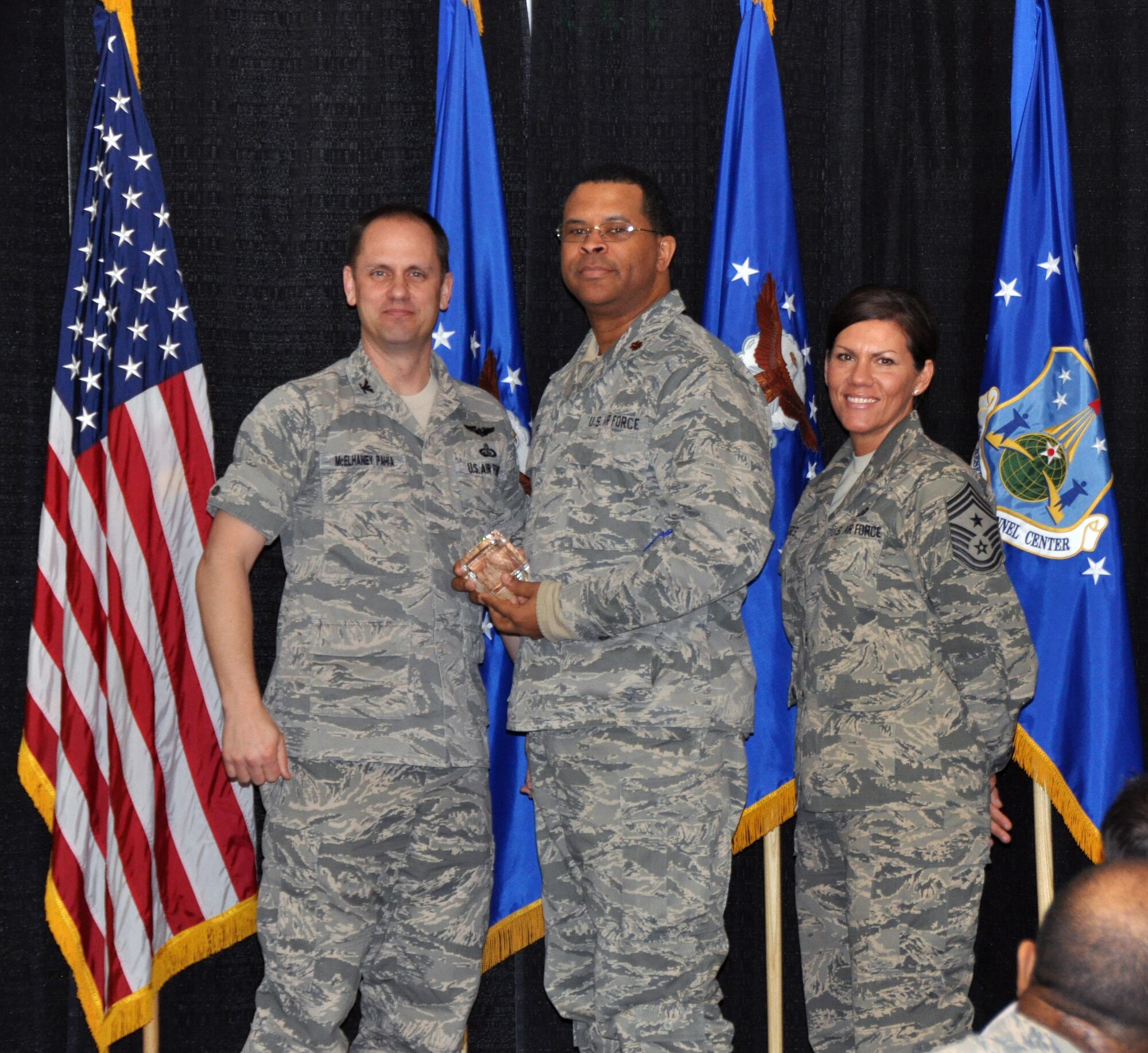 Col. Sean McElhaney Pahia, Air Reserve Personnel Center vice commander, and Chief Master Sgt. Ruthe Flores, ARPC command chief, present the Gen. Horace M. Wade Innovation Award to Maj. Elrae Epps. McElhaney Pahia honored ARPC’s 2014 outstanding performers of the year as well as their A1 annual award winners at the Summit Conference and Event Center Feb. 24, 2015, in Denver. (U.S. Air Force photo/Tech. Sgt. Rob Hazelett)