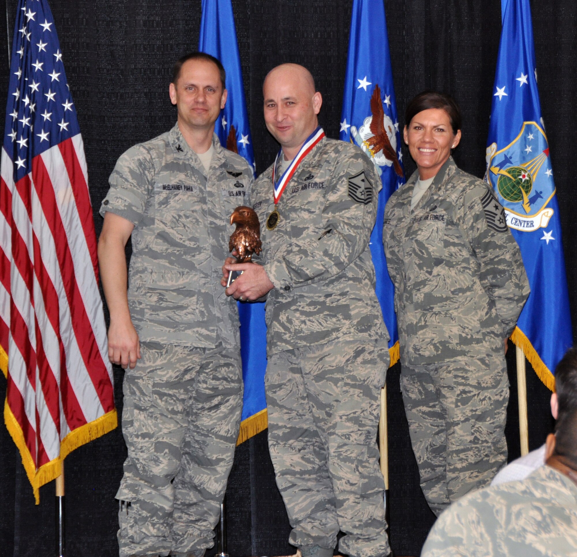 Col. Sean McElhaney Pahia, Air Reserve Personnel Center vice commander, and Chief Master Sgt. Ruthe Flores, ARPC command chief, present the ARPC First Sergeant of the Year award to Master Sgt. Jerrod Kester. McElhaney Pahia honored ARPC’s 2014 outstanding performers of the year as well as their A1 annual award winners at the Summit Conference and Event Center Feb. 24, 2015, in Denver. (U.S. Air Force photo/Tech. Sgt. Rob Hazelett)