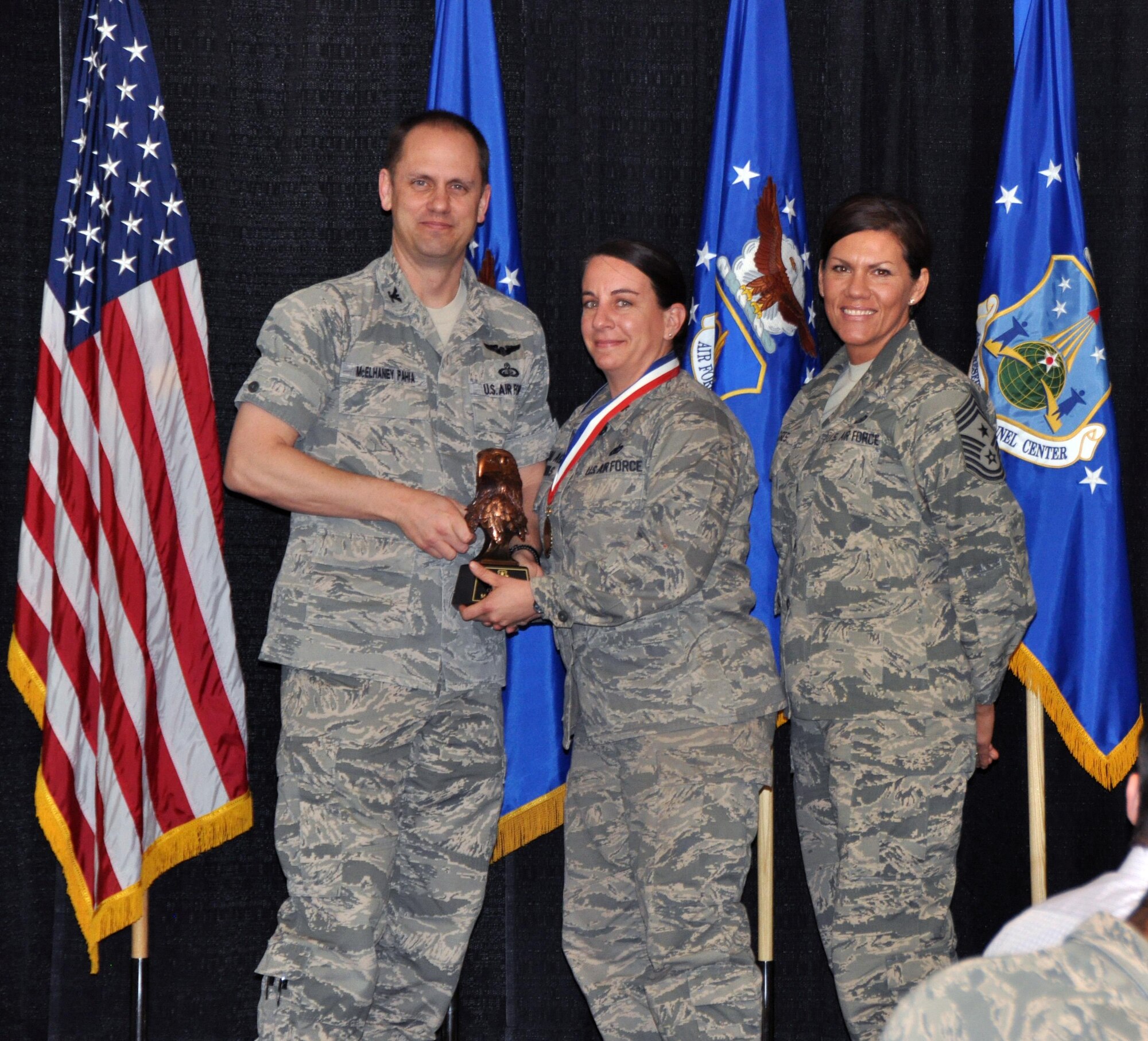 Col. Sean McElhaney Pahia, Air Reserve Personnel Center vice commander, and Chief Master Sgt. Ruthe Flores, ARPC command chief, present the ARPC Company Grade Officer of the Year award to Maj. Amber Nichols. McElhaney Pahia honored ARPC’s 2014 outstanding performers of the year as well as their A1 annual award winners at the Summit Conference and Event Center Feb. 24, 2015, in Denver. (U.S. Air Force photo/Tech. Sgt. Rob Hazelett)
