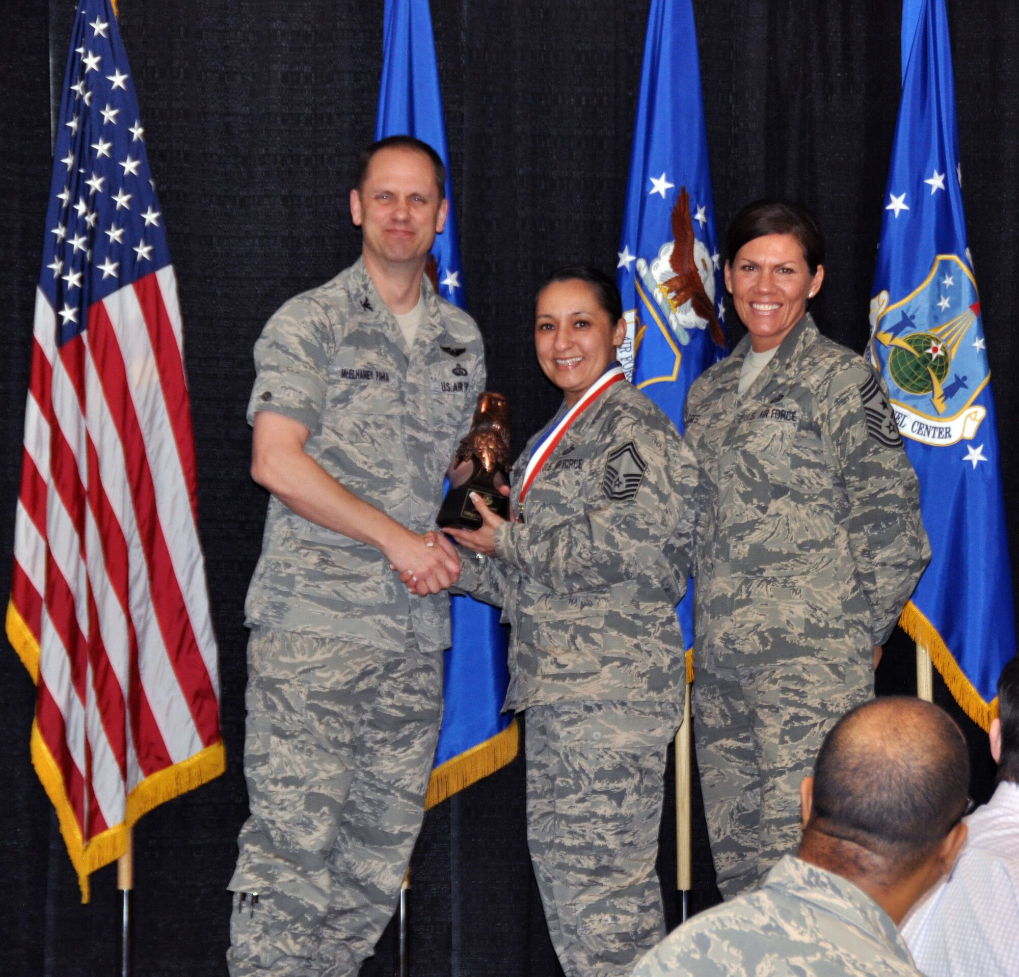 Col. Sean McElhaney Pahia, Air Reserve Personnel Center vice commander, and Chief Master Sgt. Ruthe Flores, ARPC command chief, present the ARPC Senior Noncommissioned Officer of the Year award to Senior Master Sgt. Christina Hollingshead. McElhaney Pahia honored ARPC’s 2014 outstanding performers of the year as well as their A1 annual award winners at the Summit Conference and Event Center Feb. 24, 2015, in Denver. (U.S. Air Force photo/Tech. Sgt. Rob Hazelett)