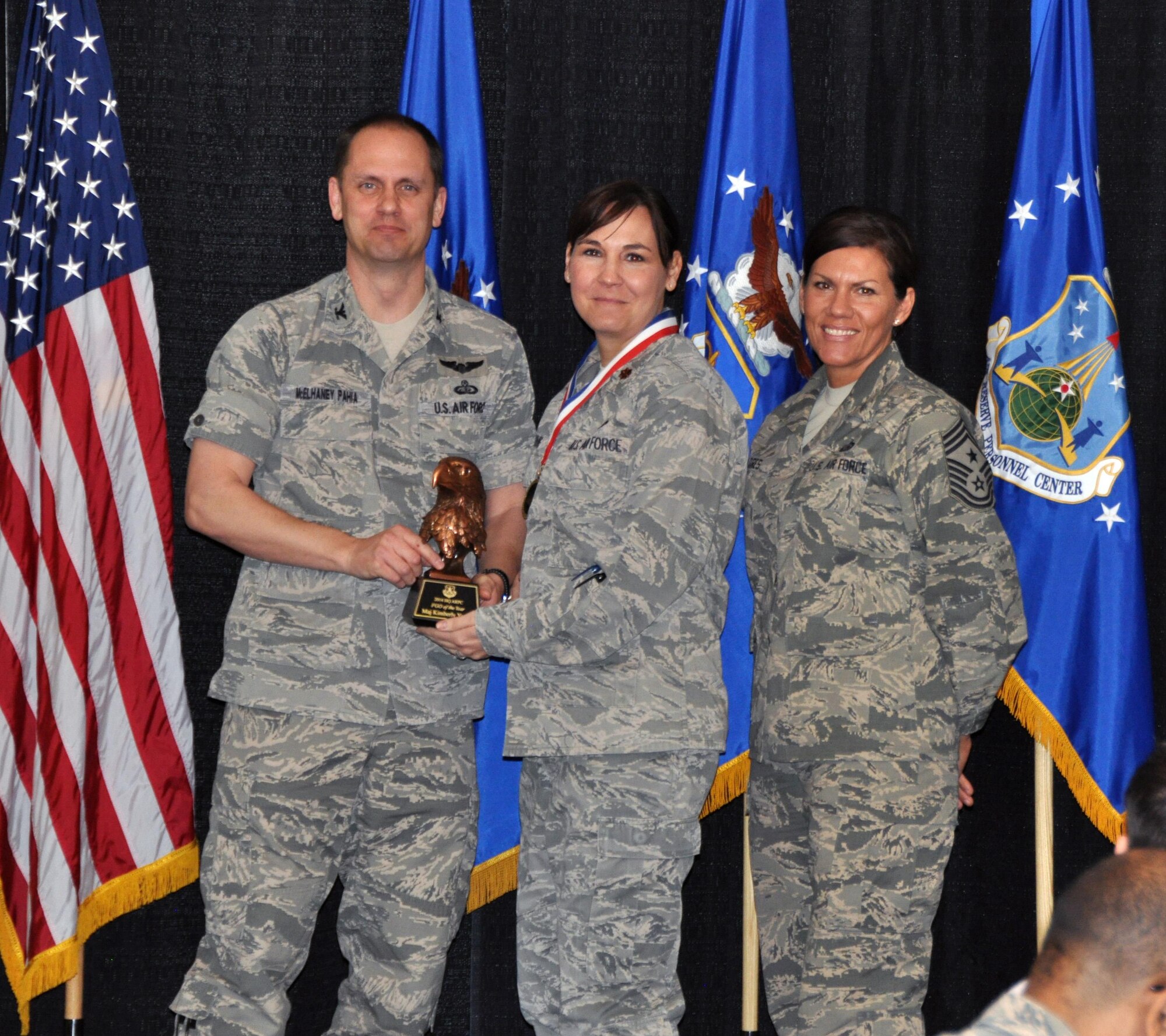 Col. Sean McElhaney Pahia, Air Reserve Personnel Center vice commander, and Chief Master Sgt. Ruthe Flores, ARPC command chief, present the ARPC Field Grade Officer of the Year award to Maj. Kimberly Young. McElhaney Pahia honored ARPC’s 2014 outstanding performers of the year as well as their A1 annual award winners at the Summit Conference and Event Center Feb. 24, 2015, in Denver. (U.S. Air Force photo/Tech. Sgt. Rob Hazelett)
