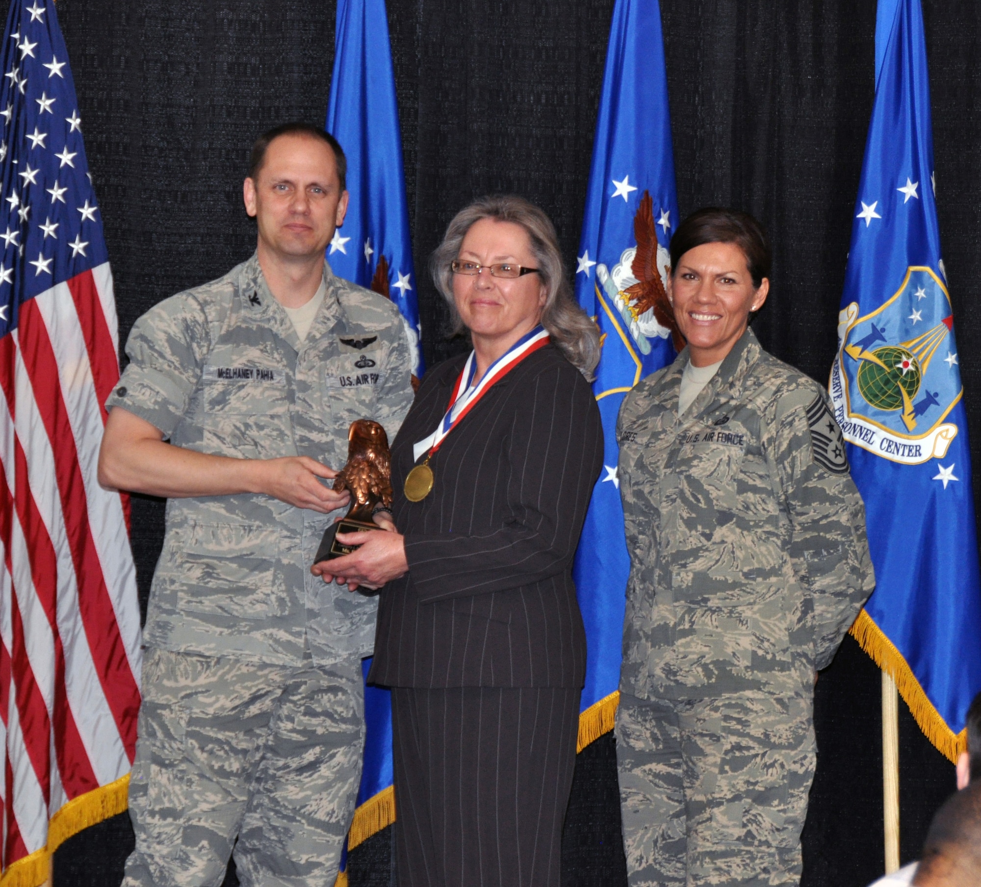 Col. Sean McElhaney Pahia, Air Reserve Personnel Center vice commander, and Chief Master Sgt. Ruthe Flores, ARPC command chief, present the Category I, Non-Supervisory Civilian of the Year award to Barbara Pac. McElhaney Pahia honored ARPC’s 2014 outstanding performers of the year as well as their A1 annual award winners at the Summit Conference and Event Center Feb. 24, 2015, in Denver. (U.S. Air Force photo/Tech. Sgt. Rob Hazelett)